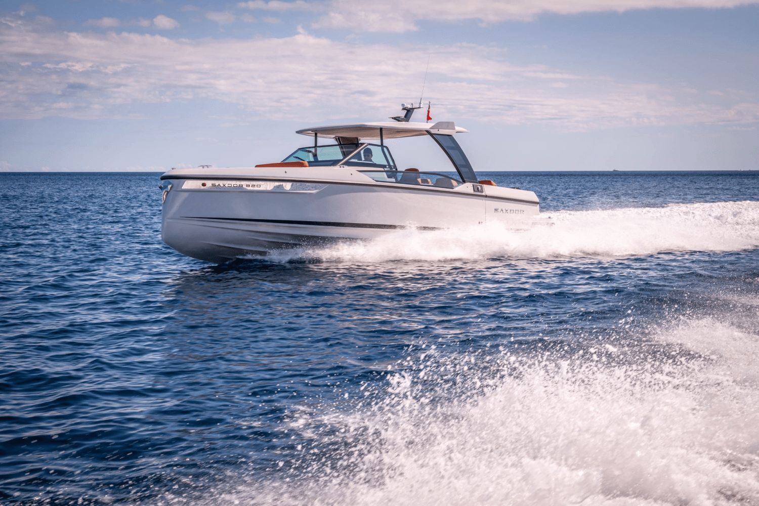 A 2027 Saxdor SX320 GTO speeds across the sea, surrounded by splashing water.