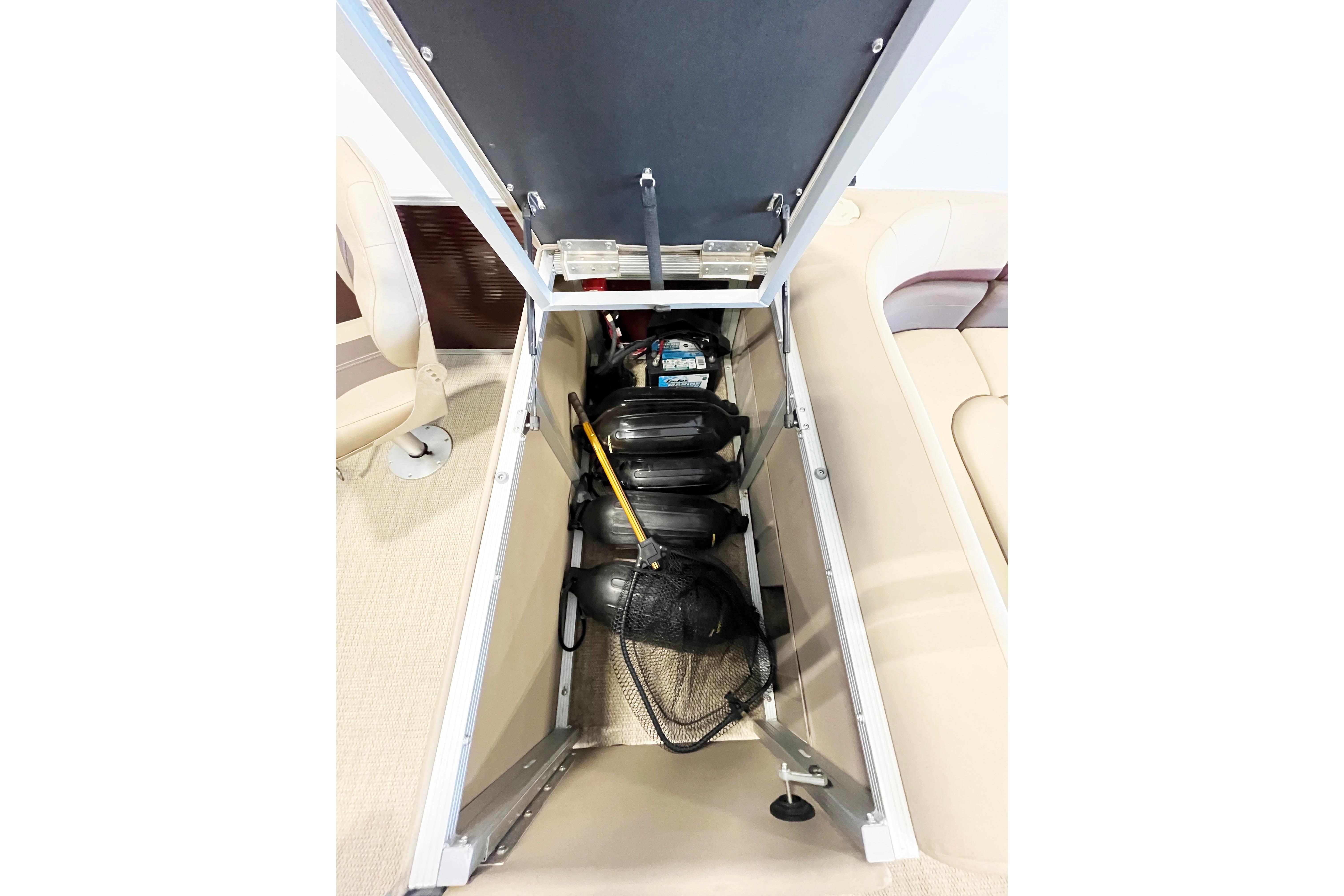 Open storage compartment in a 2020 Bennington SX25 boat, showing life jackets and equipment.
