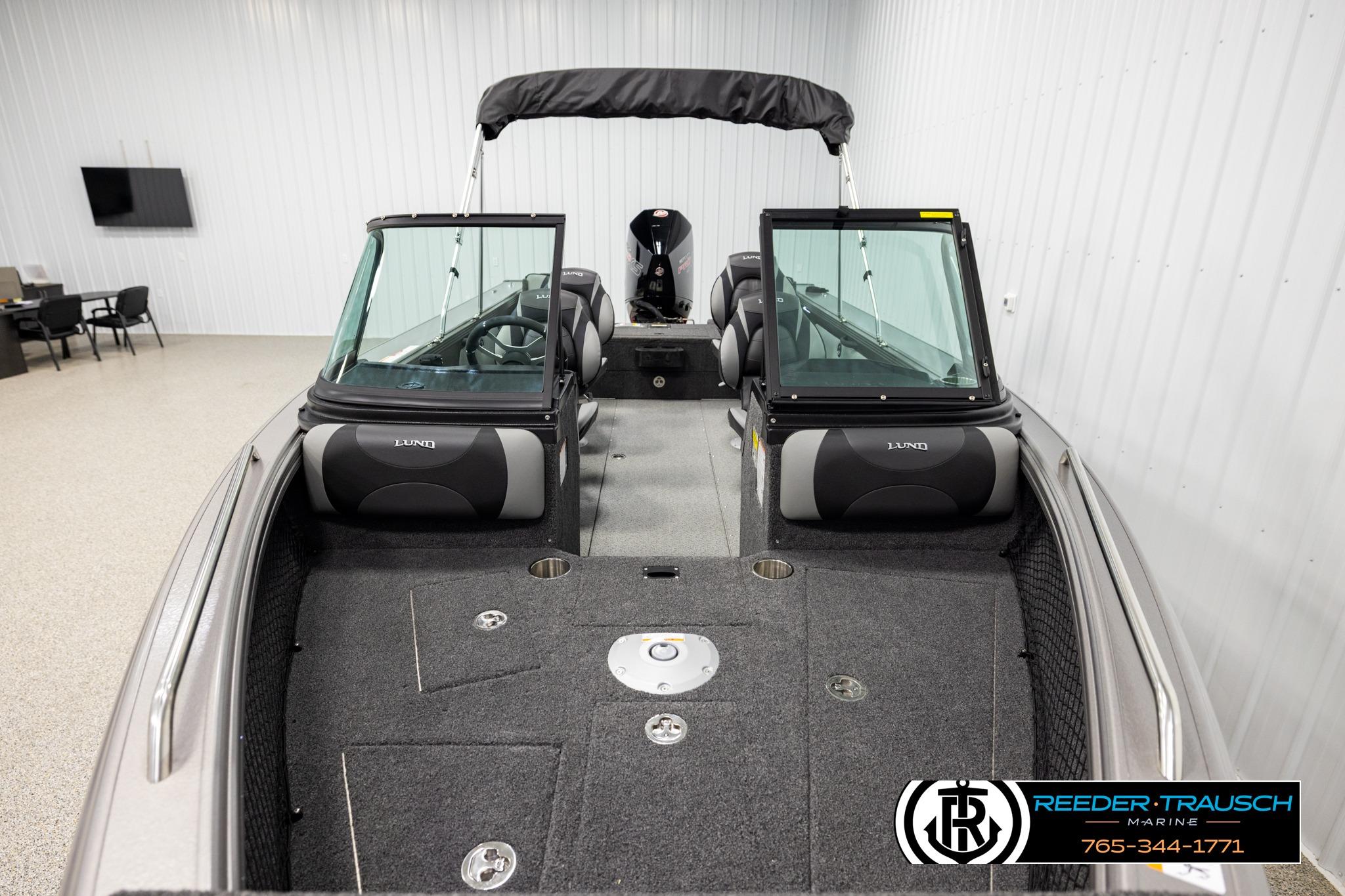 2026 Lund 1975 Tyee boat interior with seating and windshield in showroom.