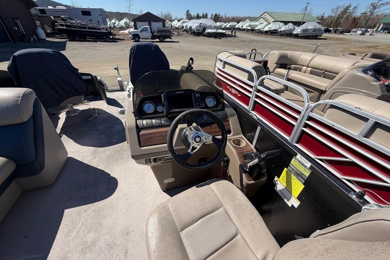 Interior of a 2013 Premier 221 Explorer pontoon boat with beige seating and control panel.