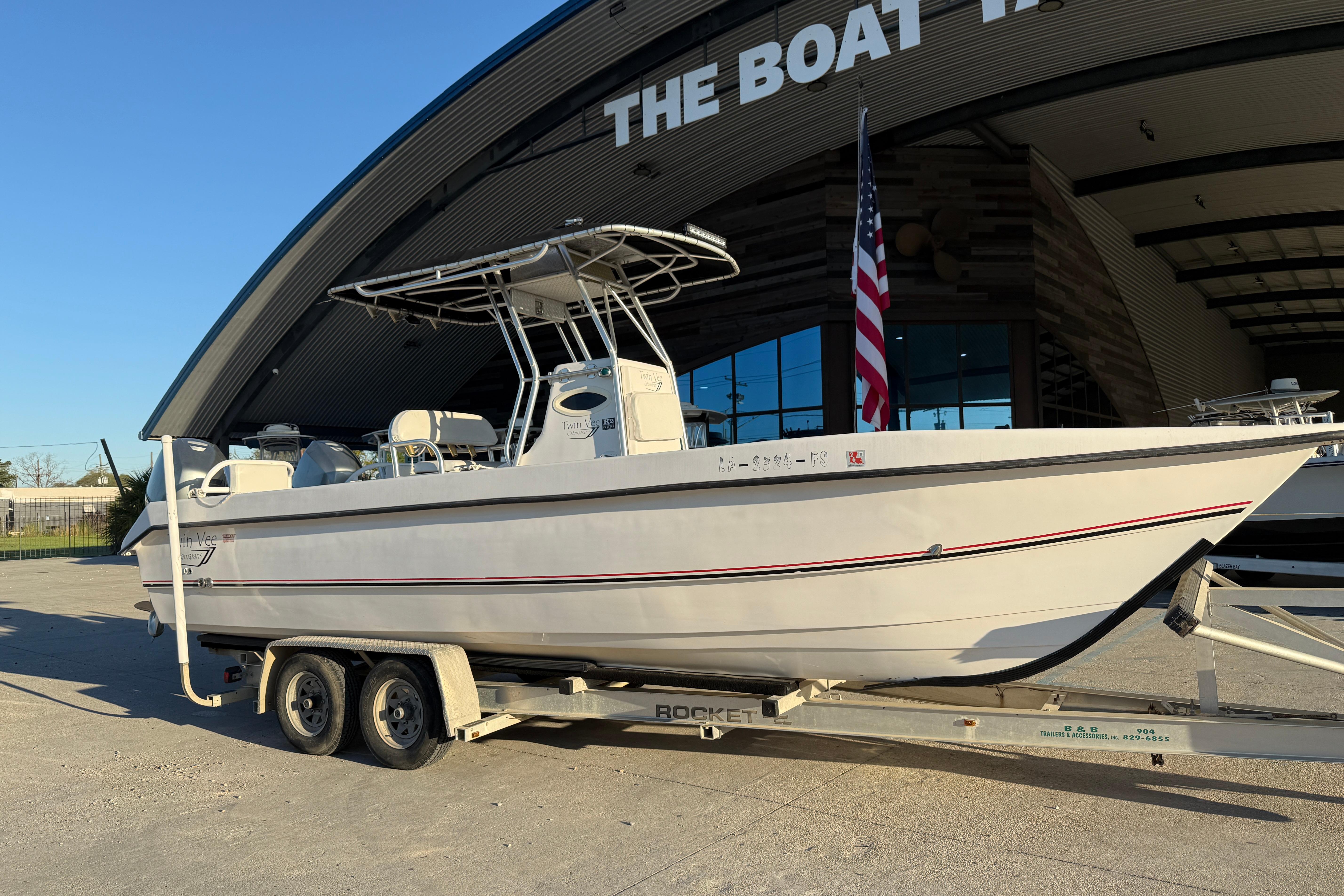 2007 Twin Vee 26 Center Console boat on trailer outside a showroom.