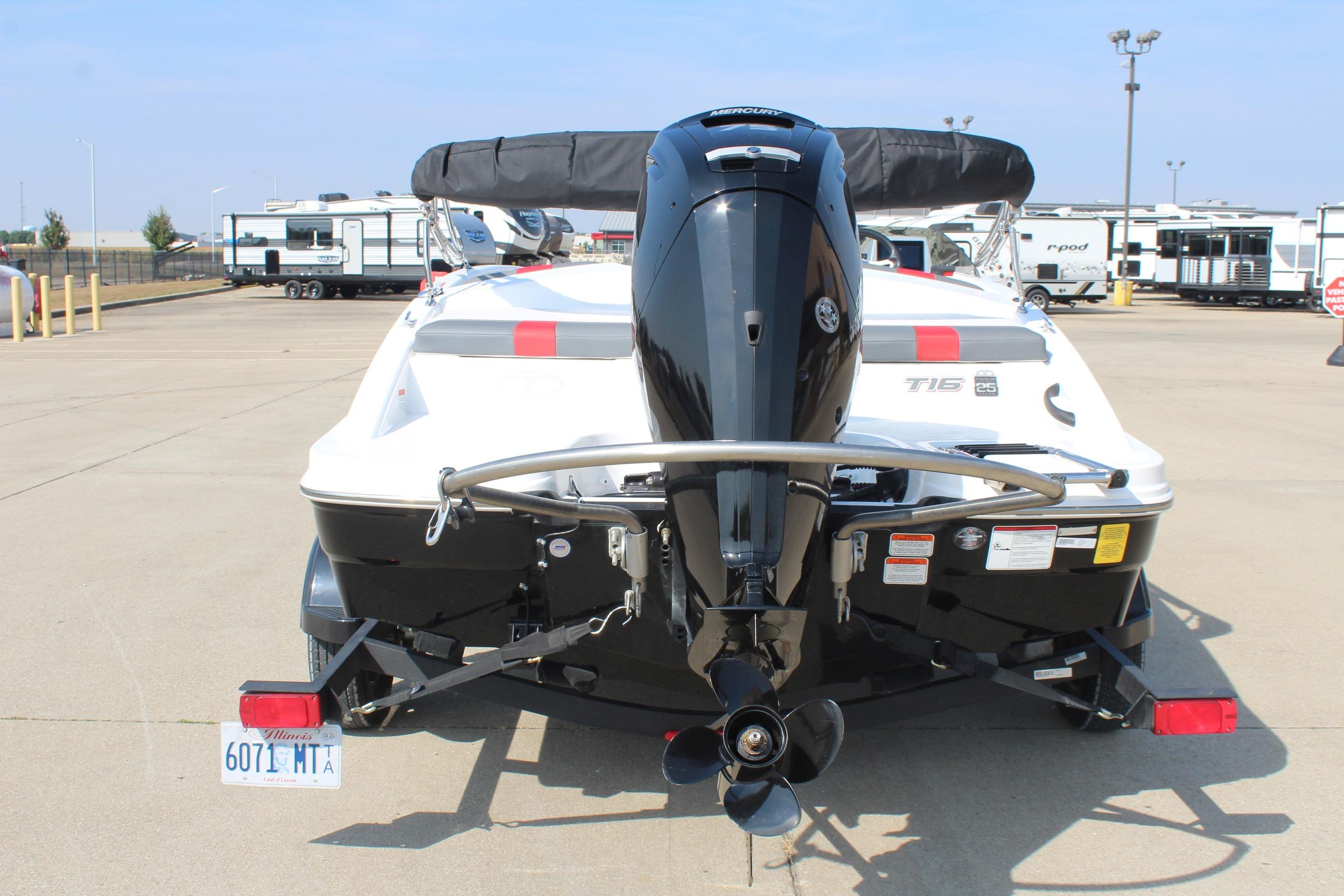 2023 Tahoe T16 boat with outboard motor, parked in a lot with trailers.