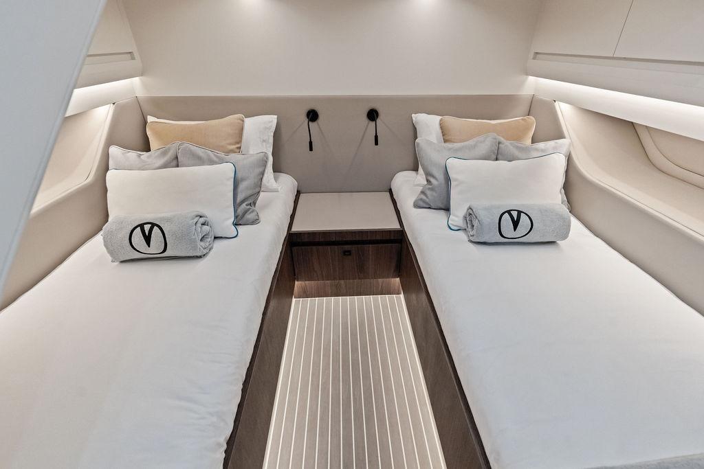 Luxurious 2024 Vanquish Yachts VQ55 cabin interior with twin beds and elegant decor.