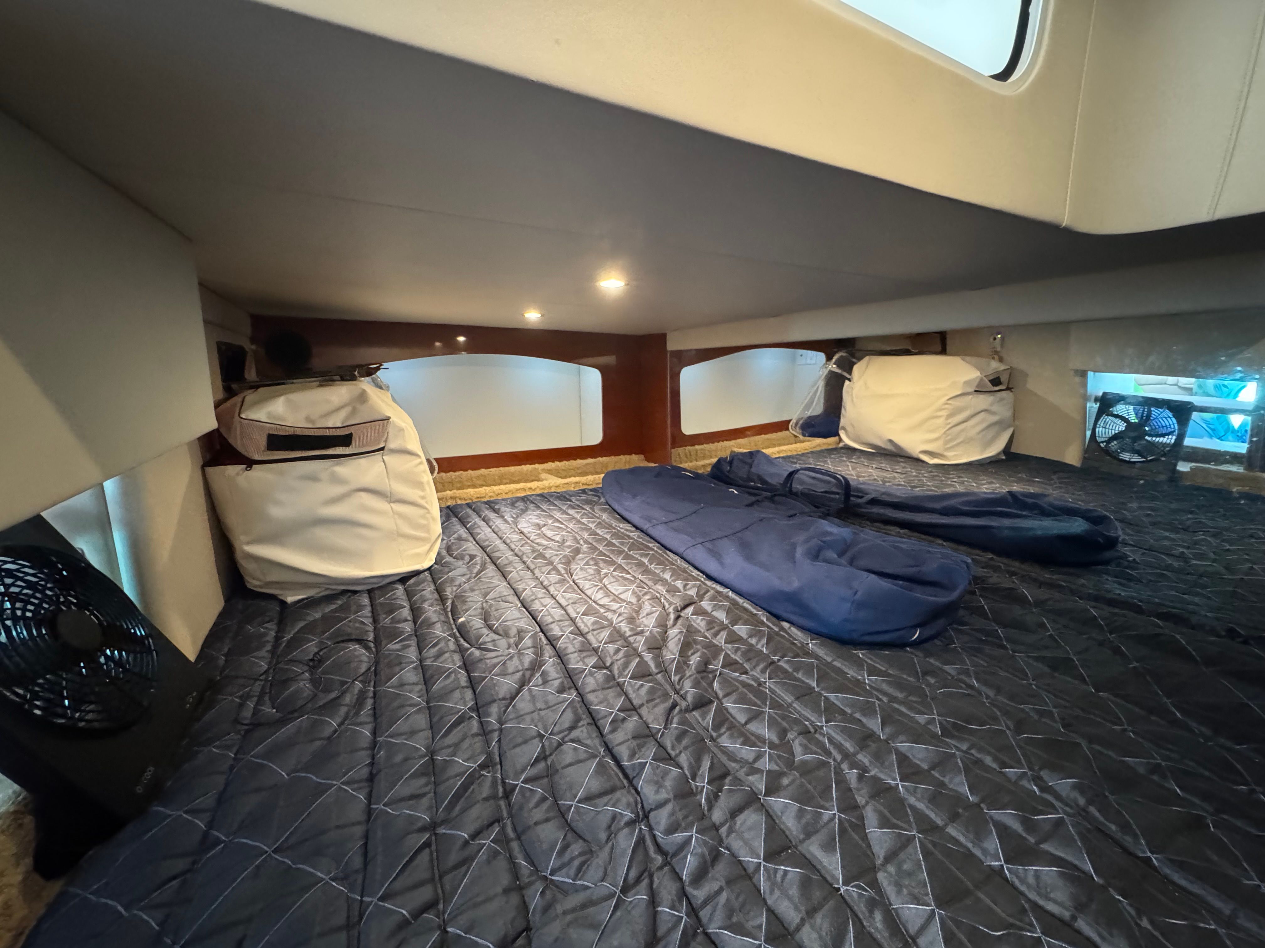 Interior of a yacht with bed and luggage.