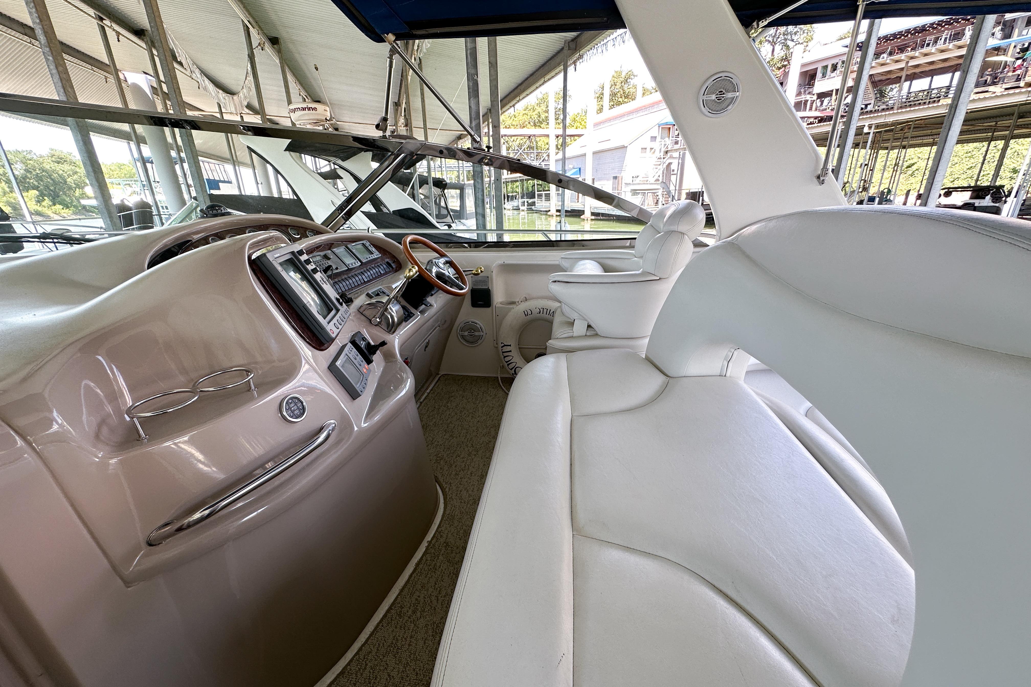 Interior of 2001 Sea Ray 410 Sundancer yacht with white seating and control panel.