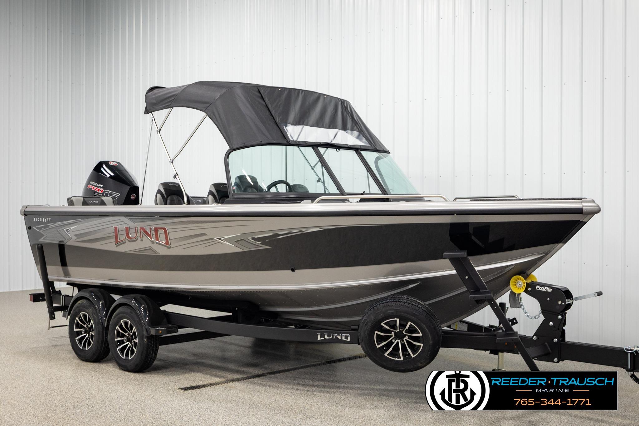 2026 Lund 1975 Tyee boat with canopy on trailer in showroom.