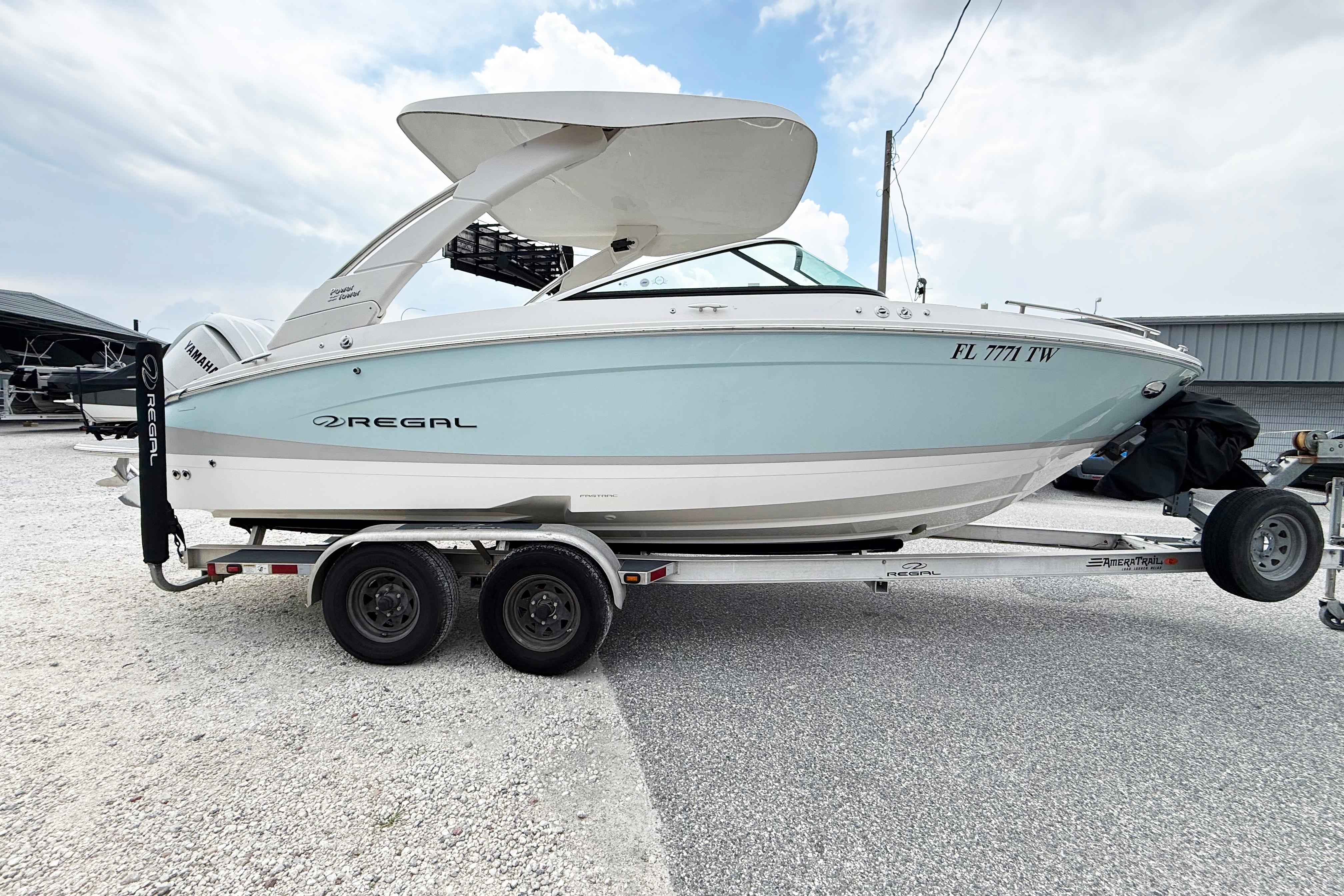 2024 Regal LX4 boat on trailer, light blue hull, parked outdoors.