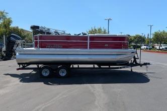 2026 Sun Tracker Party Barge 20 DLX pontoon boat on trailer, parked outdoors.