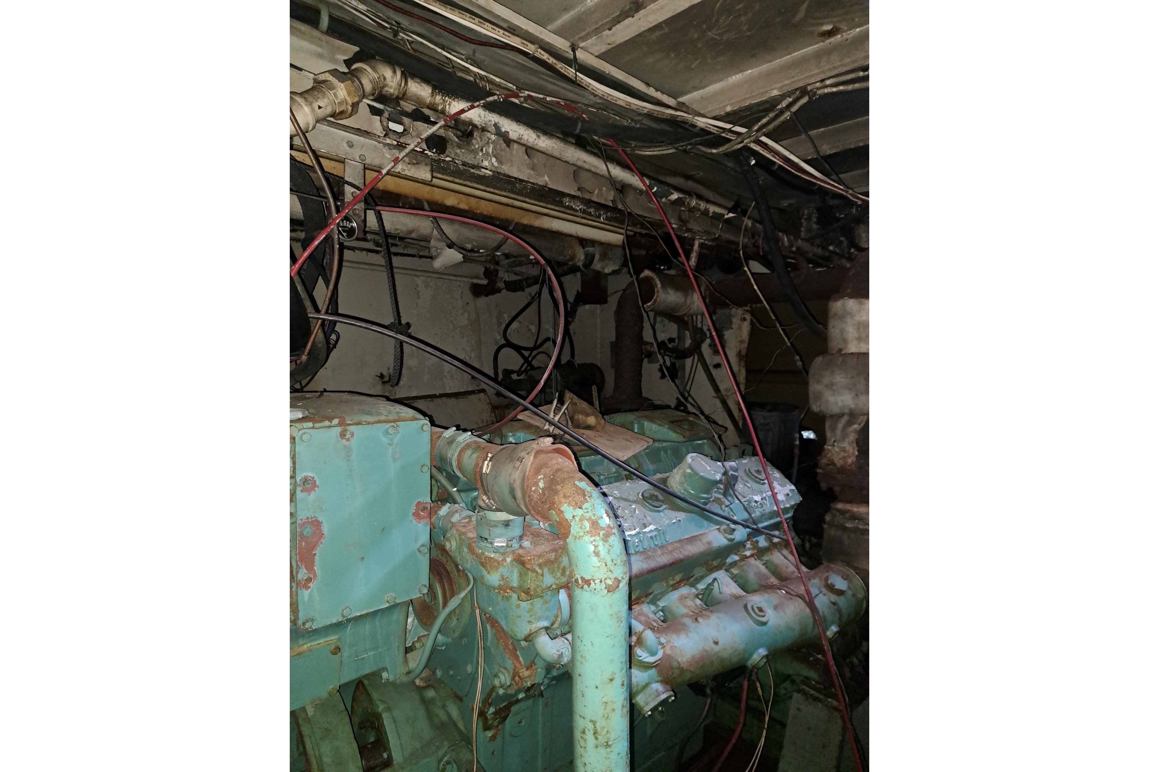 Engine room of a 1979 Custom Steel Trawler Dragger with visible wiring and machinery.