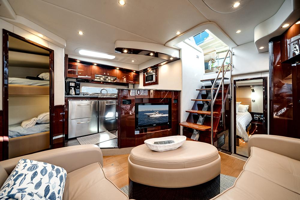 Luxurious interior of 2012 Sea Ray 610 Sundancer yacht with modern kitchen and cozy seating area.