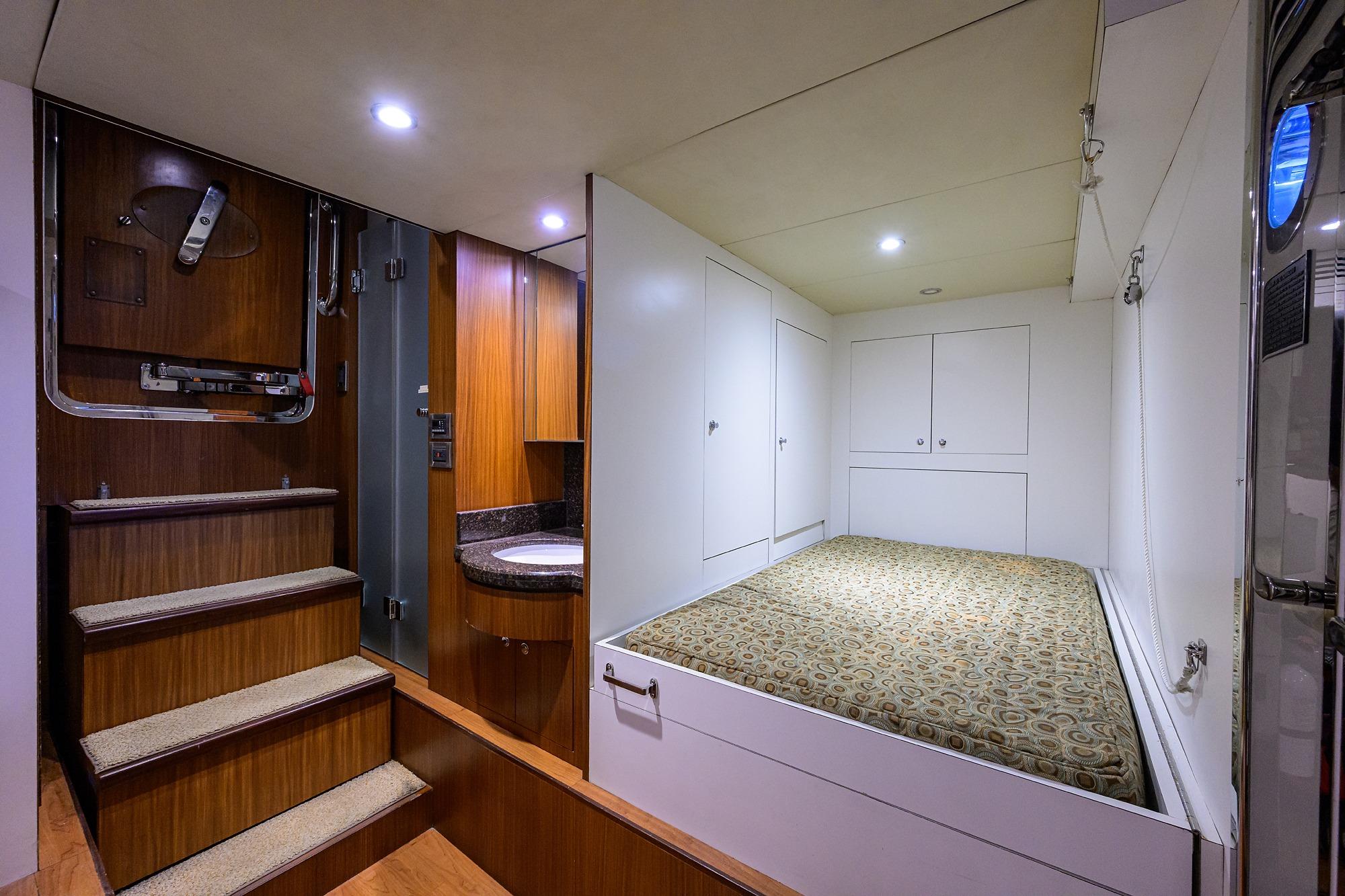 Luxurious interior of 2016 Ocean Alexander 72 Pilothouse with cozy bed and wooden accents.