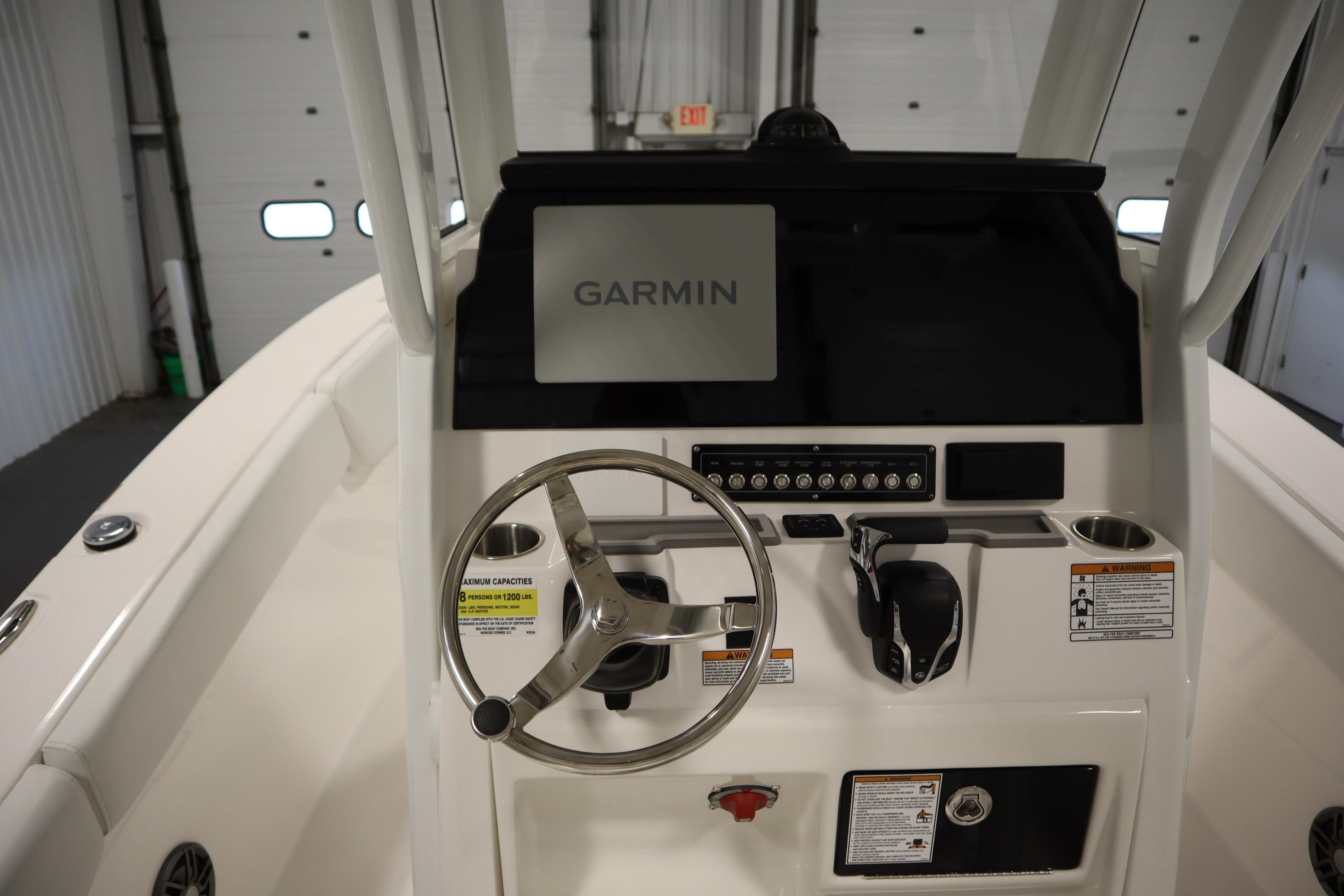 2026 Sea Fox 228 Commander boat dashboard with Garmin navigation system and steering wheel.