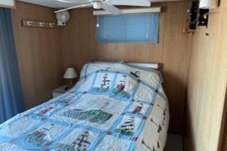 Cozy bedroom in 1994 PlayCraft 5215 with nautical-themed bedding and wooden walls.