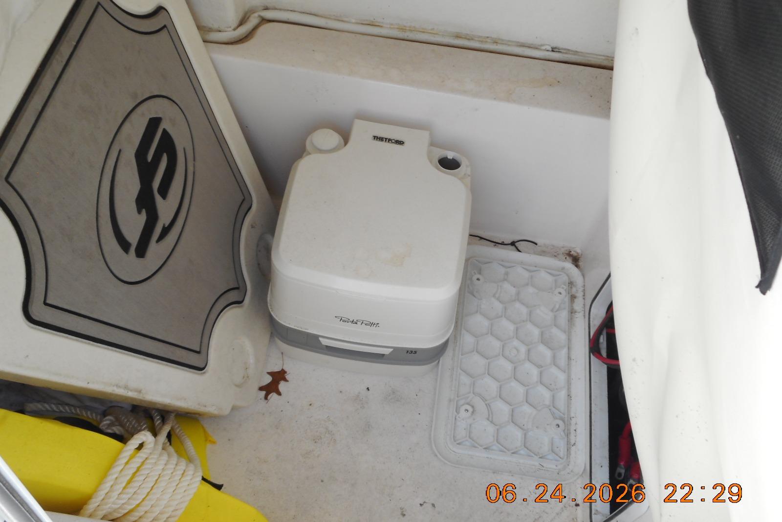 Interior of a 2022 Sea Fox 228 Commander boat with portable toilet and storage area.