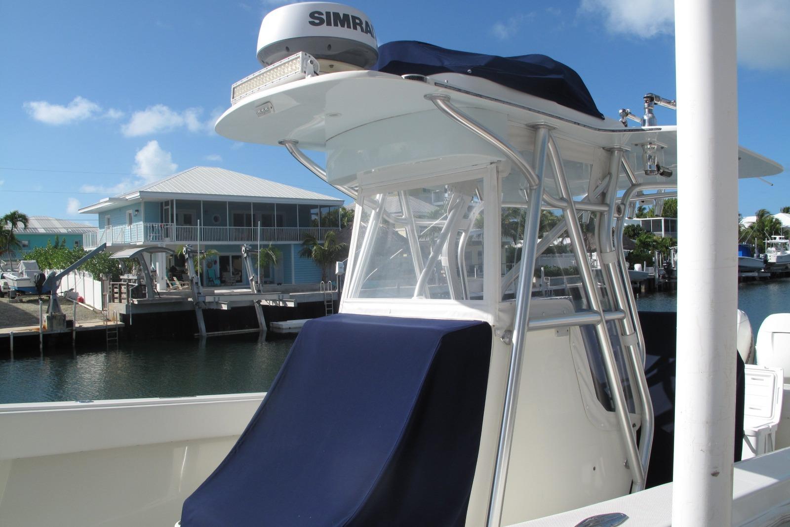 2017 SeaVee 340B boat docked near waterfront homes under a clear blue sky.