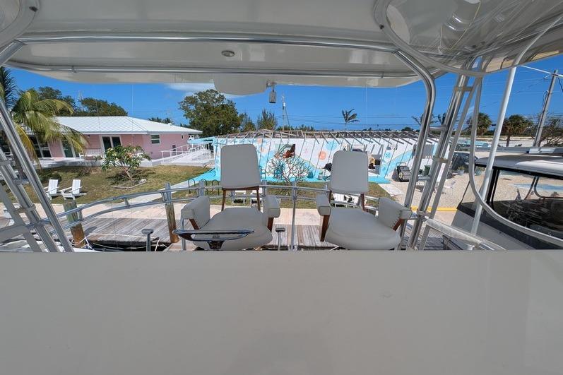 2005 Egg Harbor 43 SportYacht helm with two white captain chairs, overlooking marina.