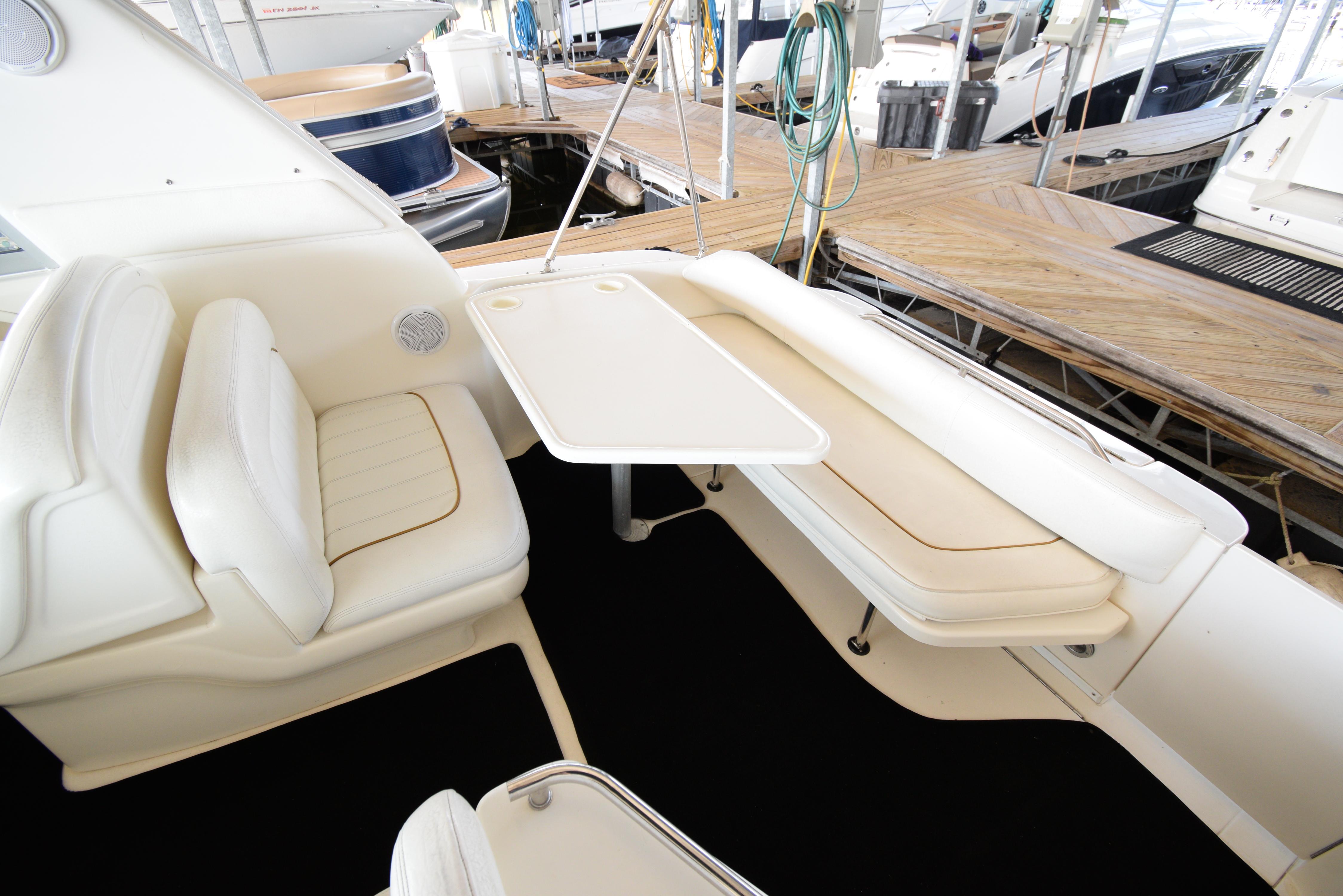 1999 Sea Ray 290 Sundancer boat interior with seating and table at dock.