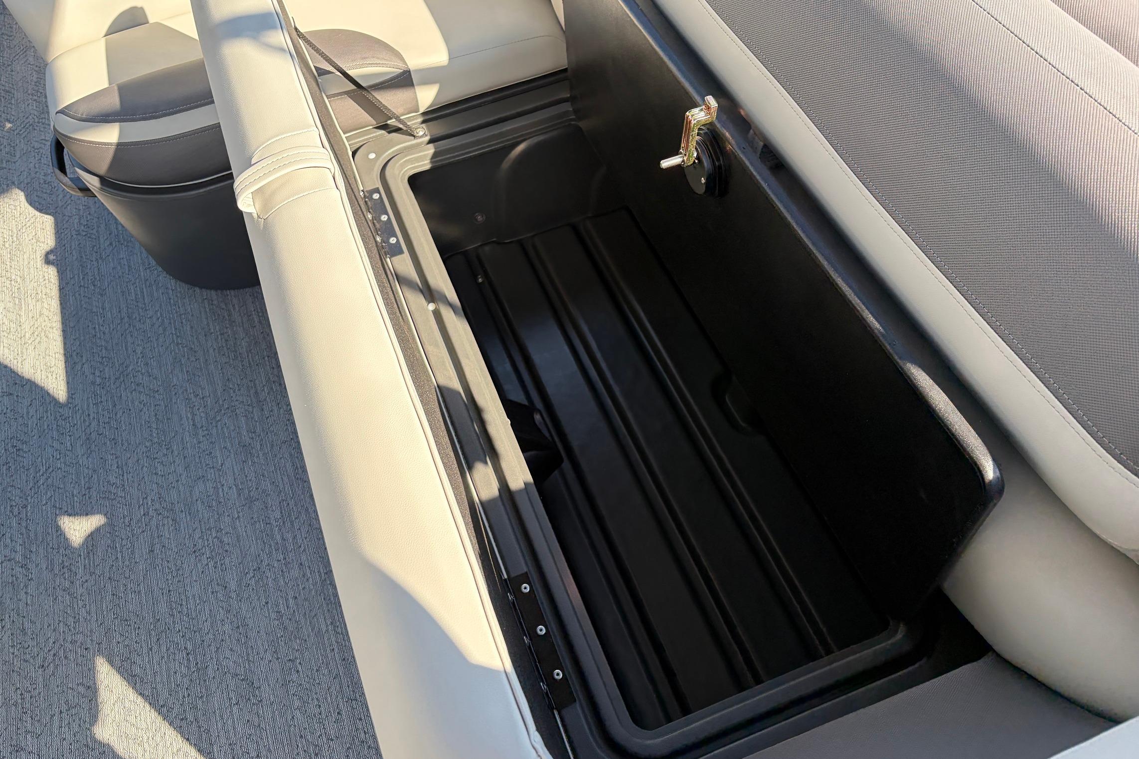 Sun Tracker Fishin' Barge 22 XP3 2026, open storage compartment with cushioned seating.