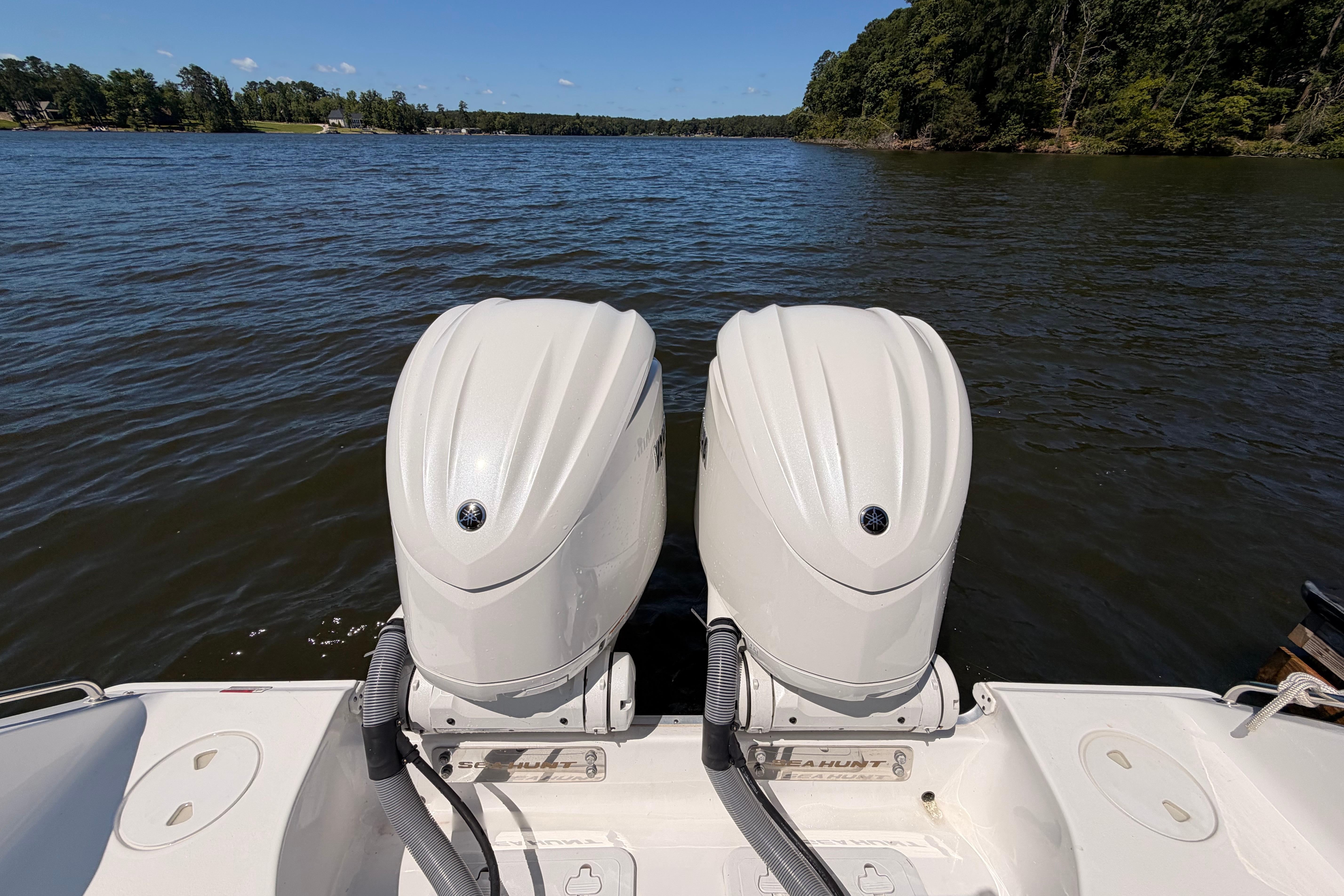 2024 Sea Hunt Gamefish 27 Coffin Box with dual outboard motors on a lake.