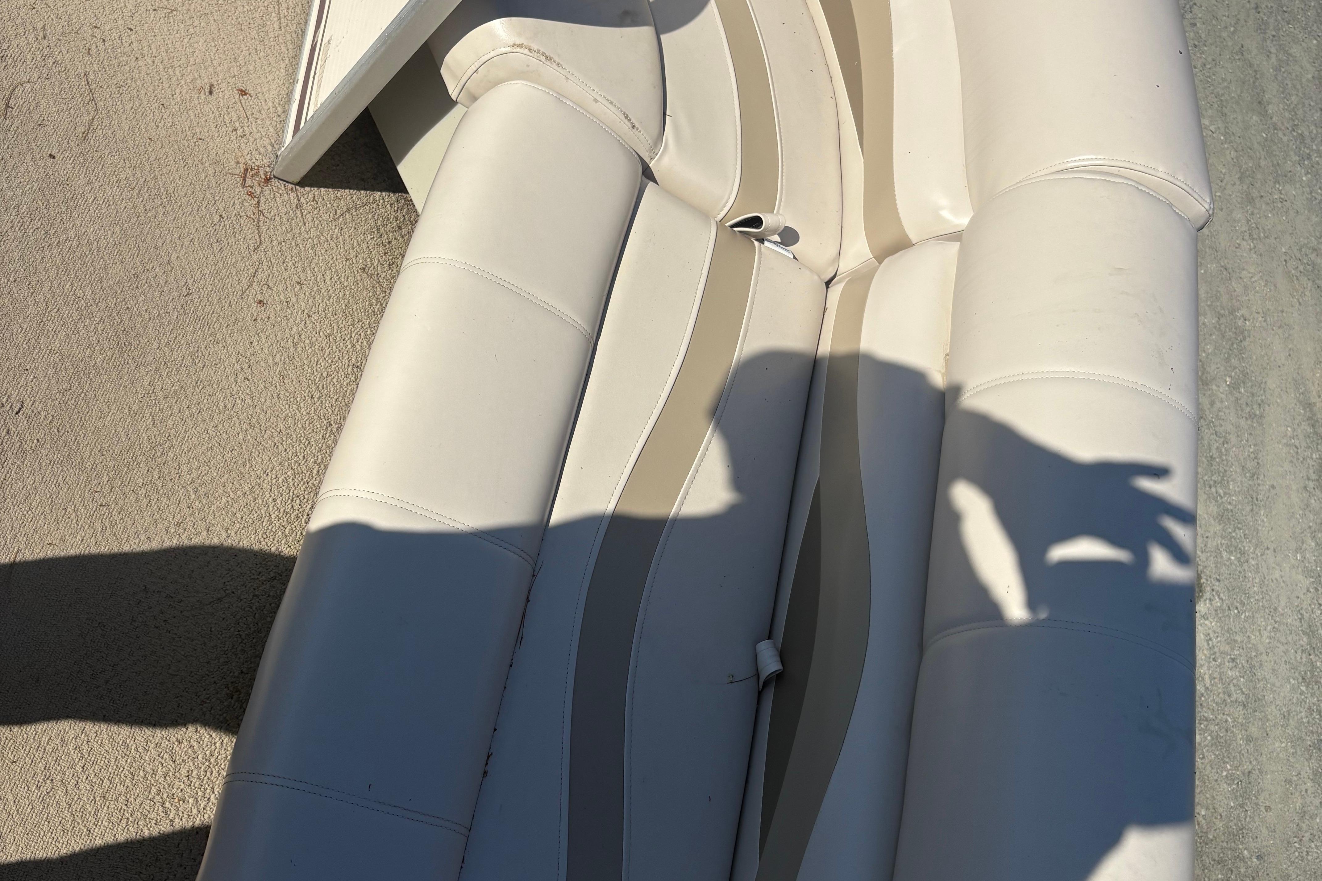 White leather seating on a 2003 Aqua Patio 200RE boat, with shadow cast on it.