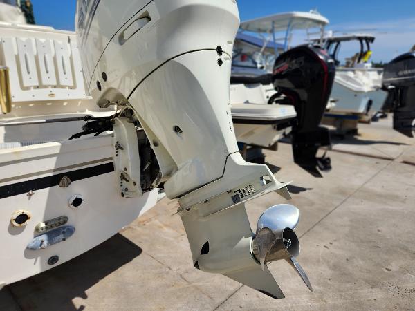 2005 Pursuit 3070 Offshore Center Console boat with outboard motor, docked in marina.