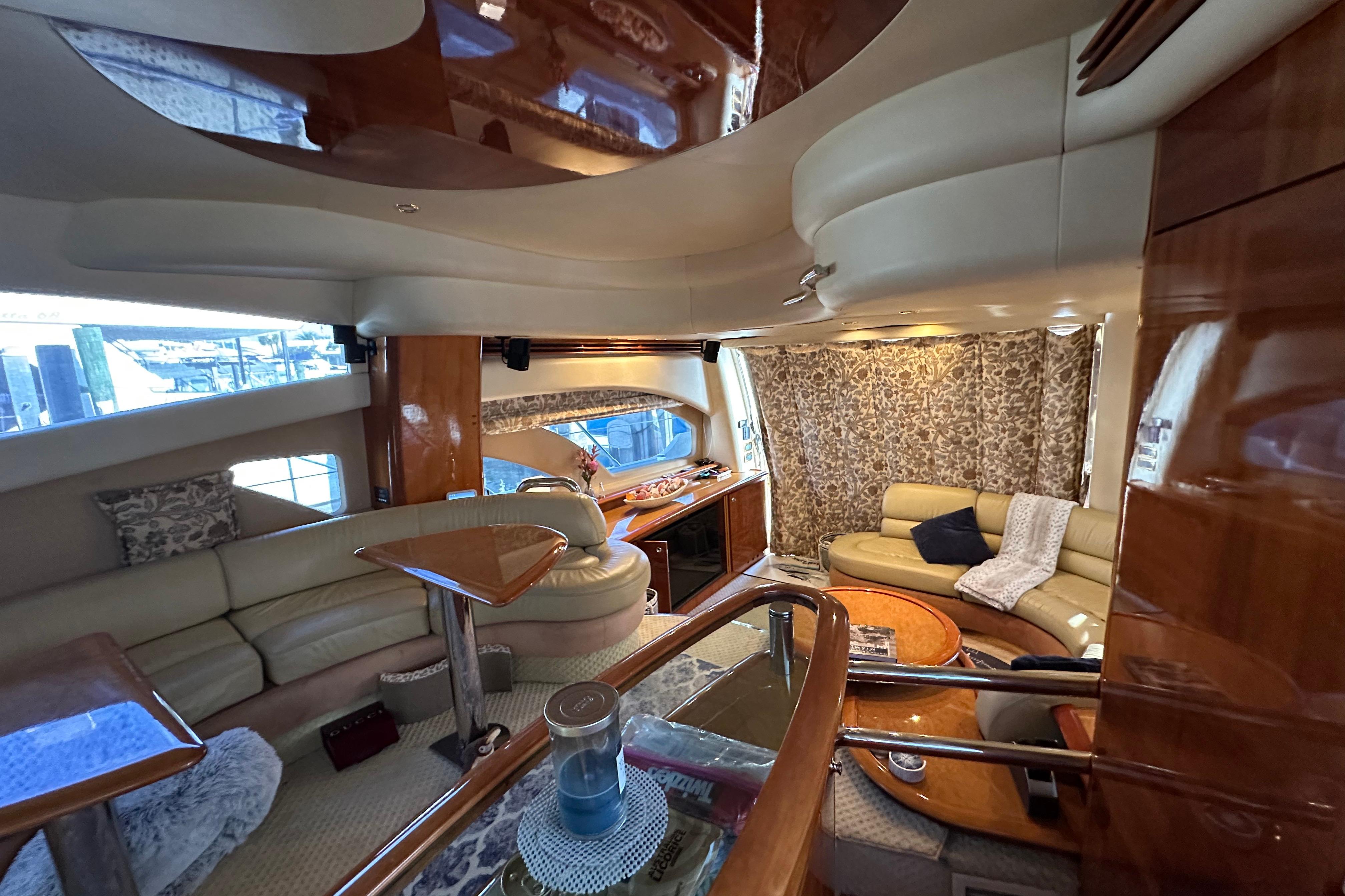 Luxurious interior of a 2004 Azimut 55E yacht with elegant seating and wood finishes.