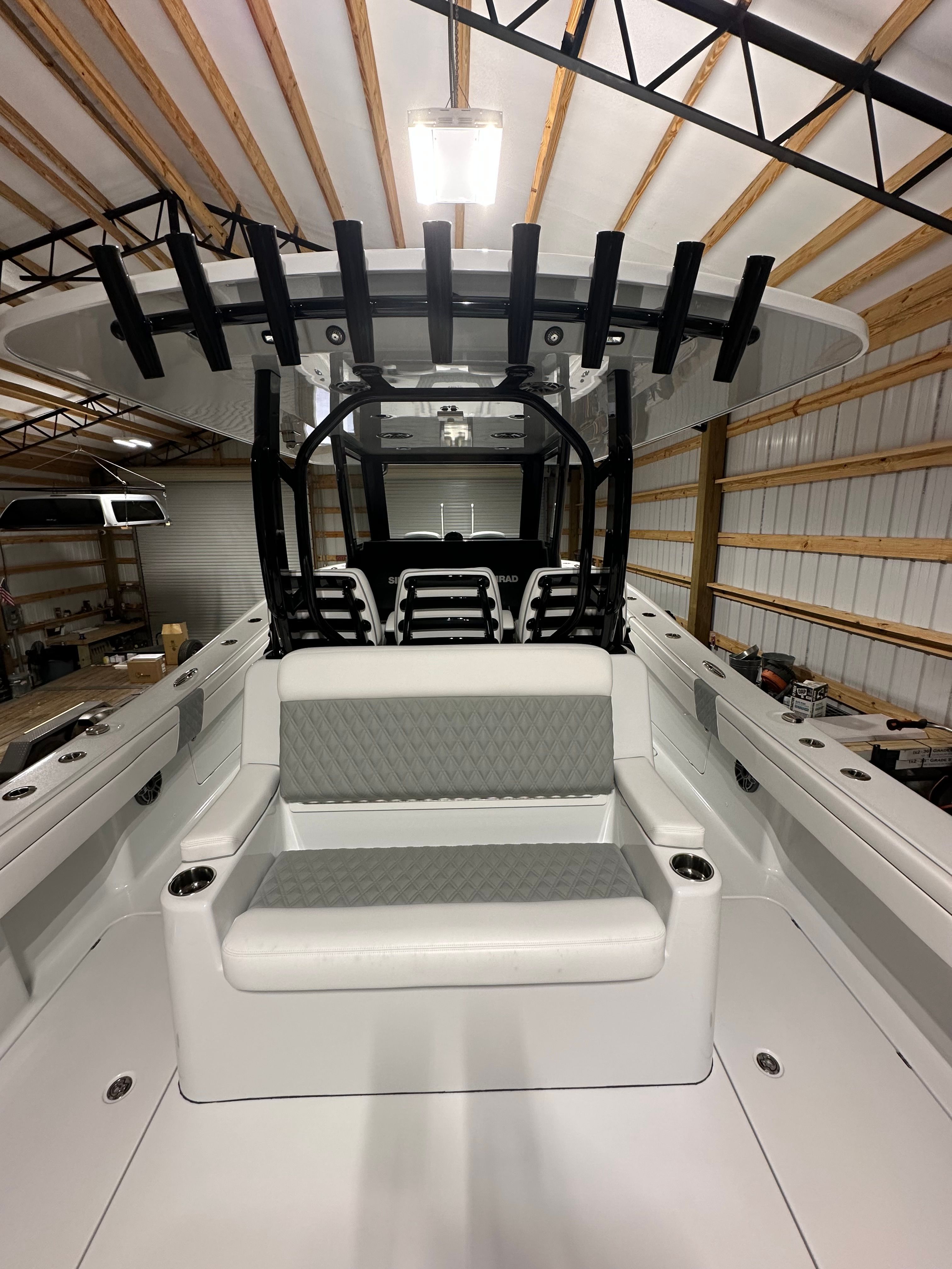 A modern boat with seating and canopy inside a storage facility.