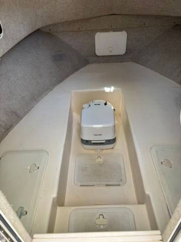Interior of a 2008 Parker 2310 Walkaround with storage compartments and a portable toilet.