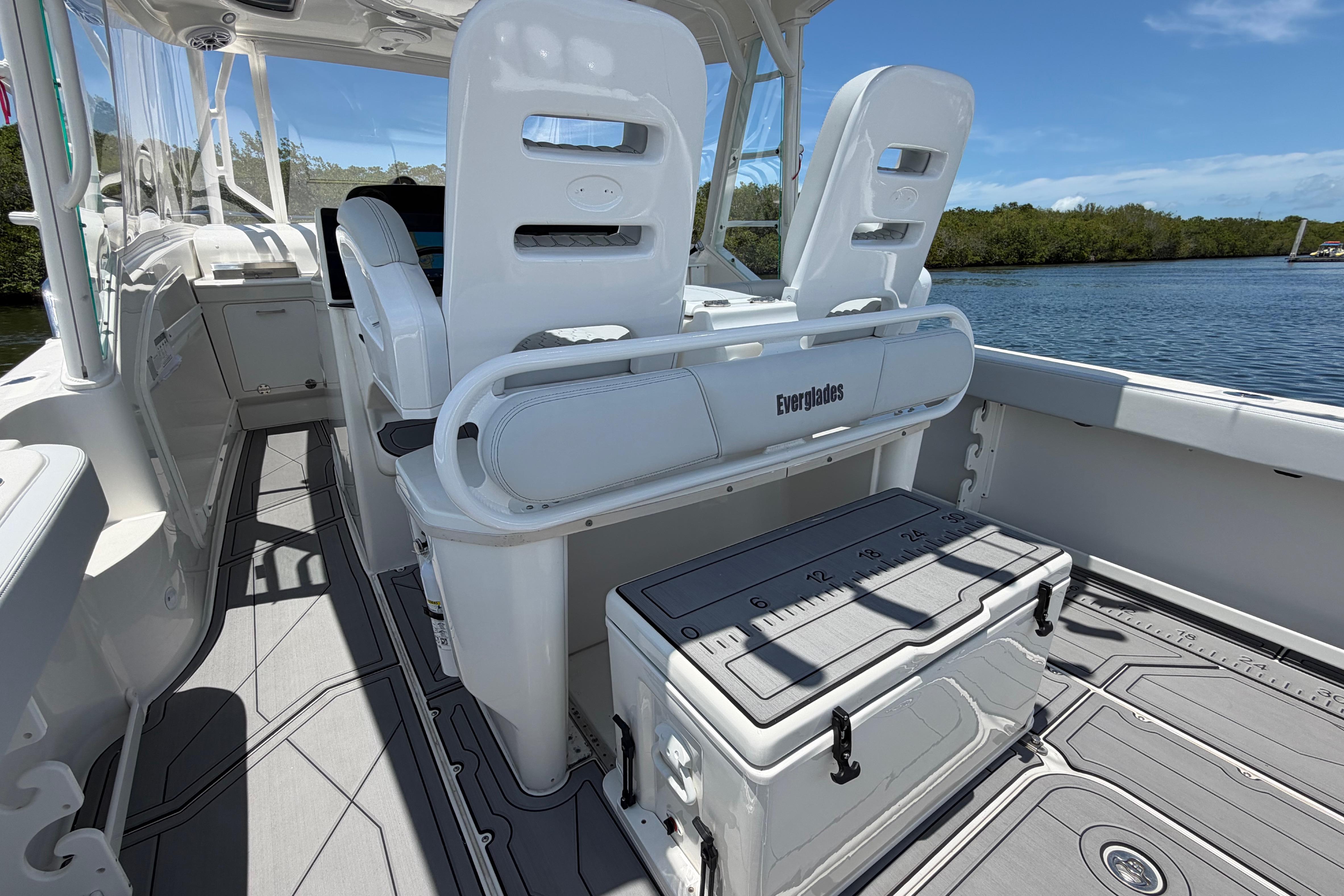 2009 Everglades 350LX boat interior with seating and storage, docked by a scenic waterway.