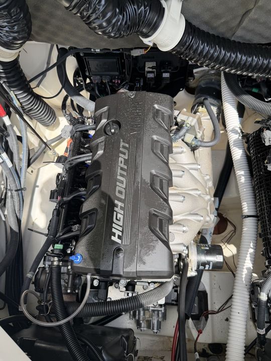 Engine compartment of a Yamaha 212SD boat with a high-output engine and various cables and hoses.