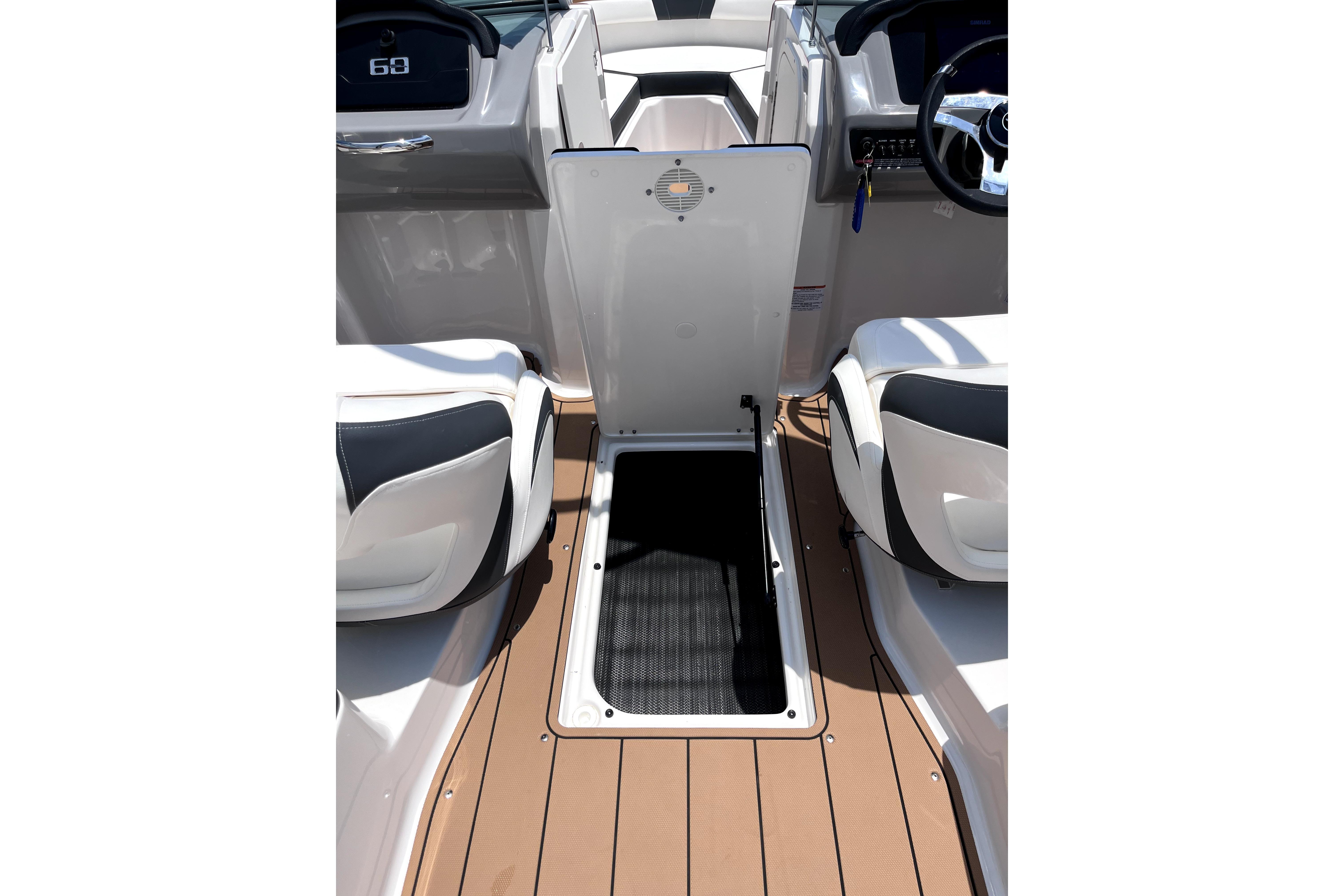2025 Chaparral 230 SSi boat interior with open storage compartment and seating.
