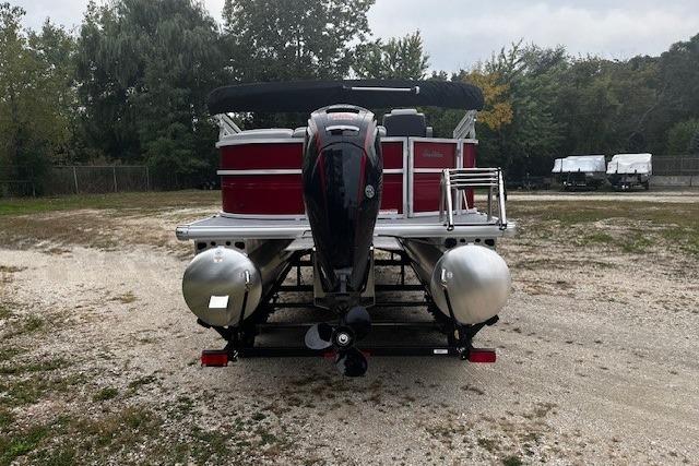 2026 Sun Tracker Party Barge 20 DLX pontoon boat, rear view, parked on gravel.