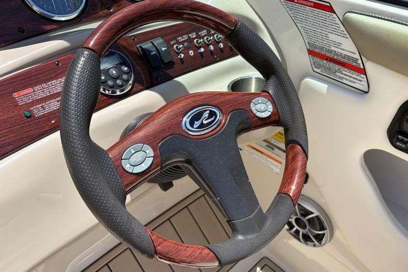 Steering wheel of a 2007 Sea Ray 240 Sundeck boat with wood accents.