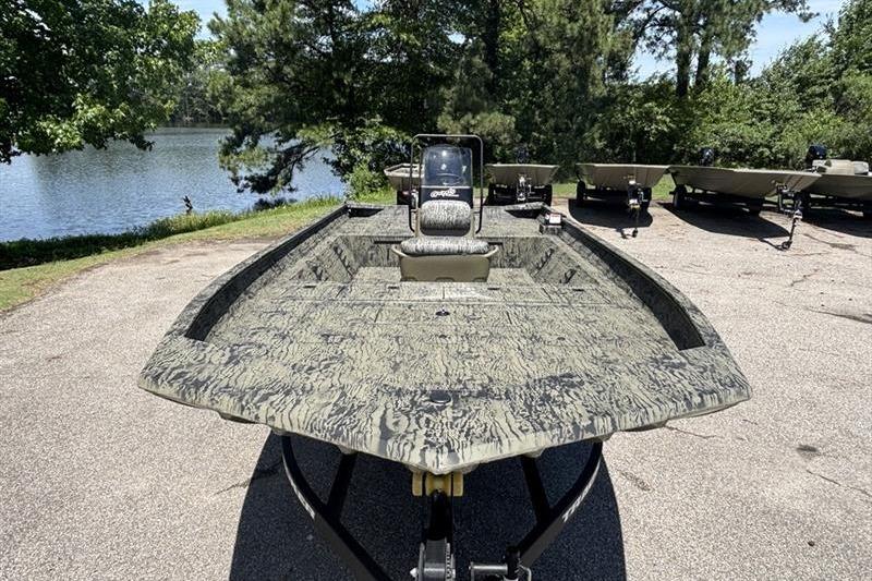 2026 Tracker Grizzly 2072 CC boat parked near a scenic lake.