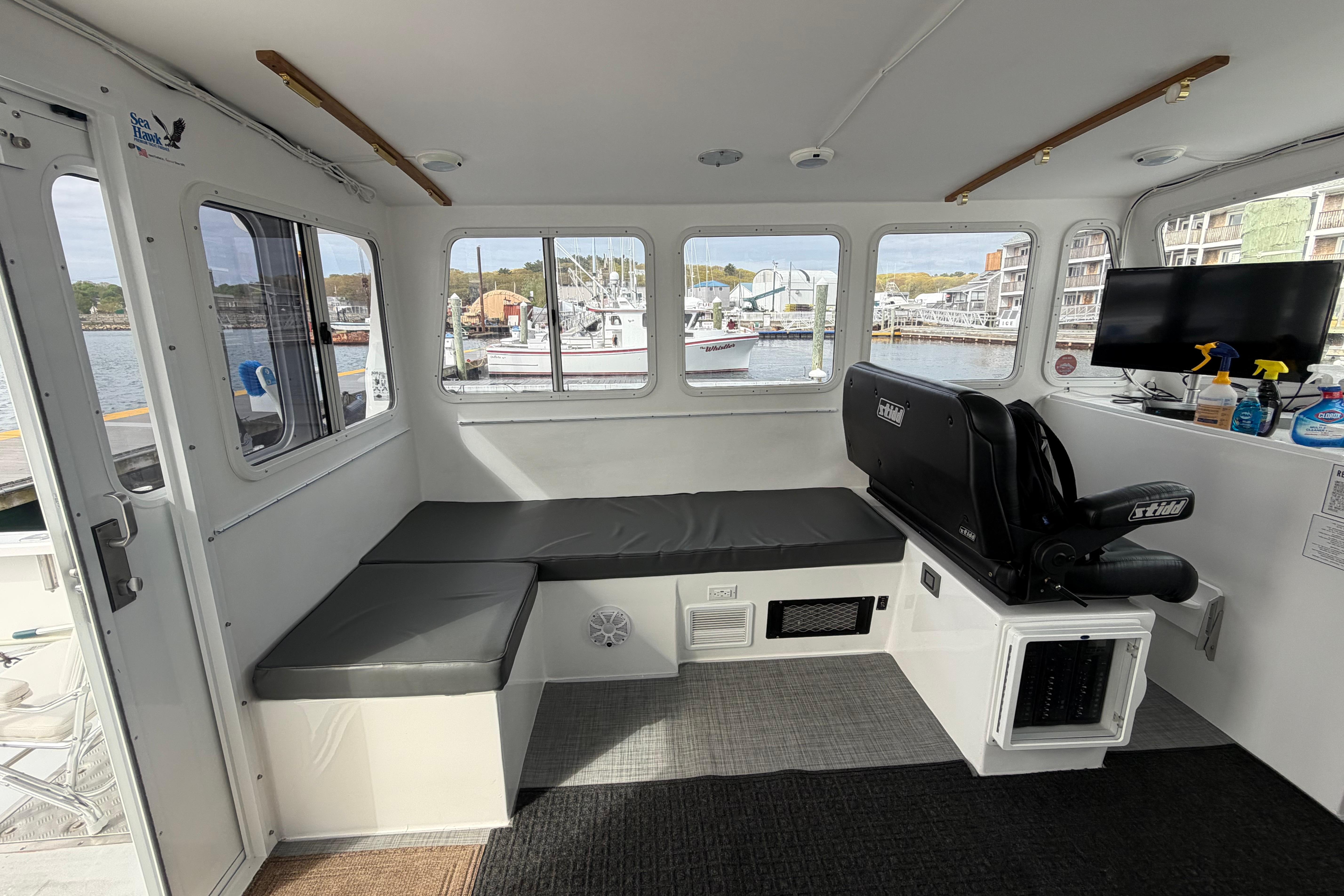 Interior of 2018 H&H Marine Osmond Beal boat with seating and waterfront view.