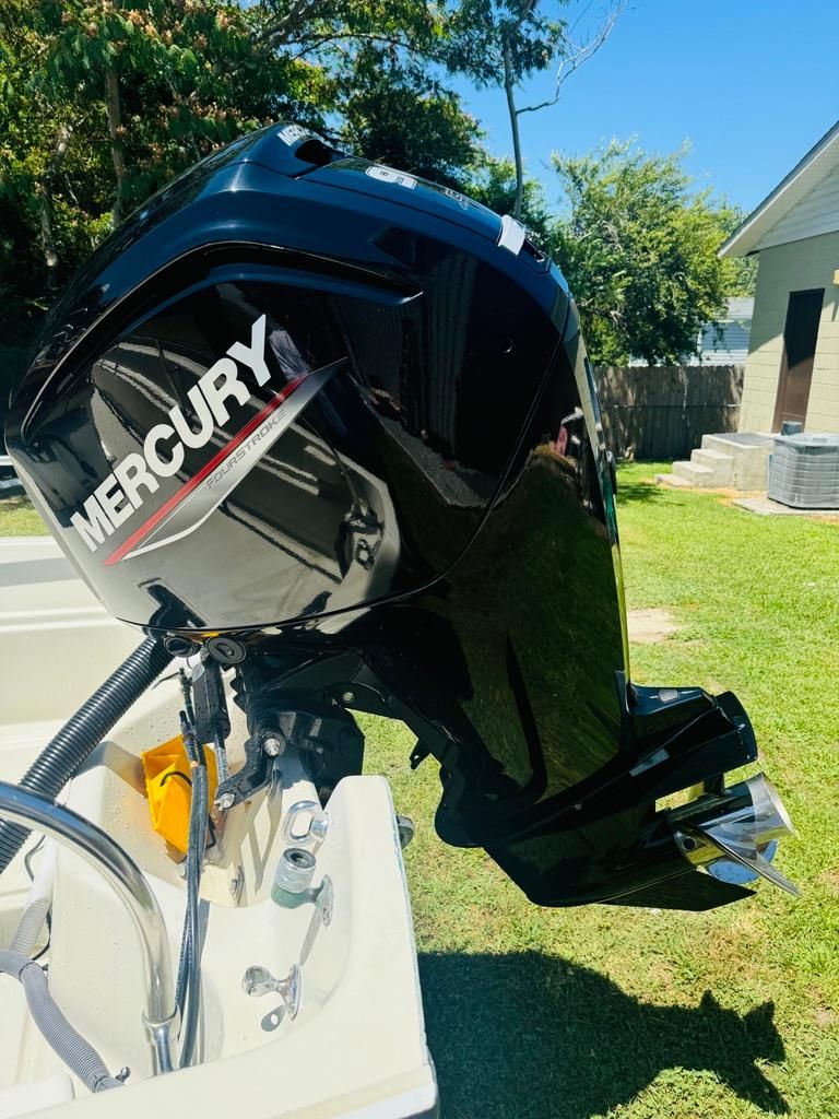 A Mercury outboard motor is mounted on a 1986 Boston Whaler 17 Montauk, set outdoors.