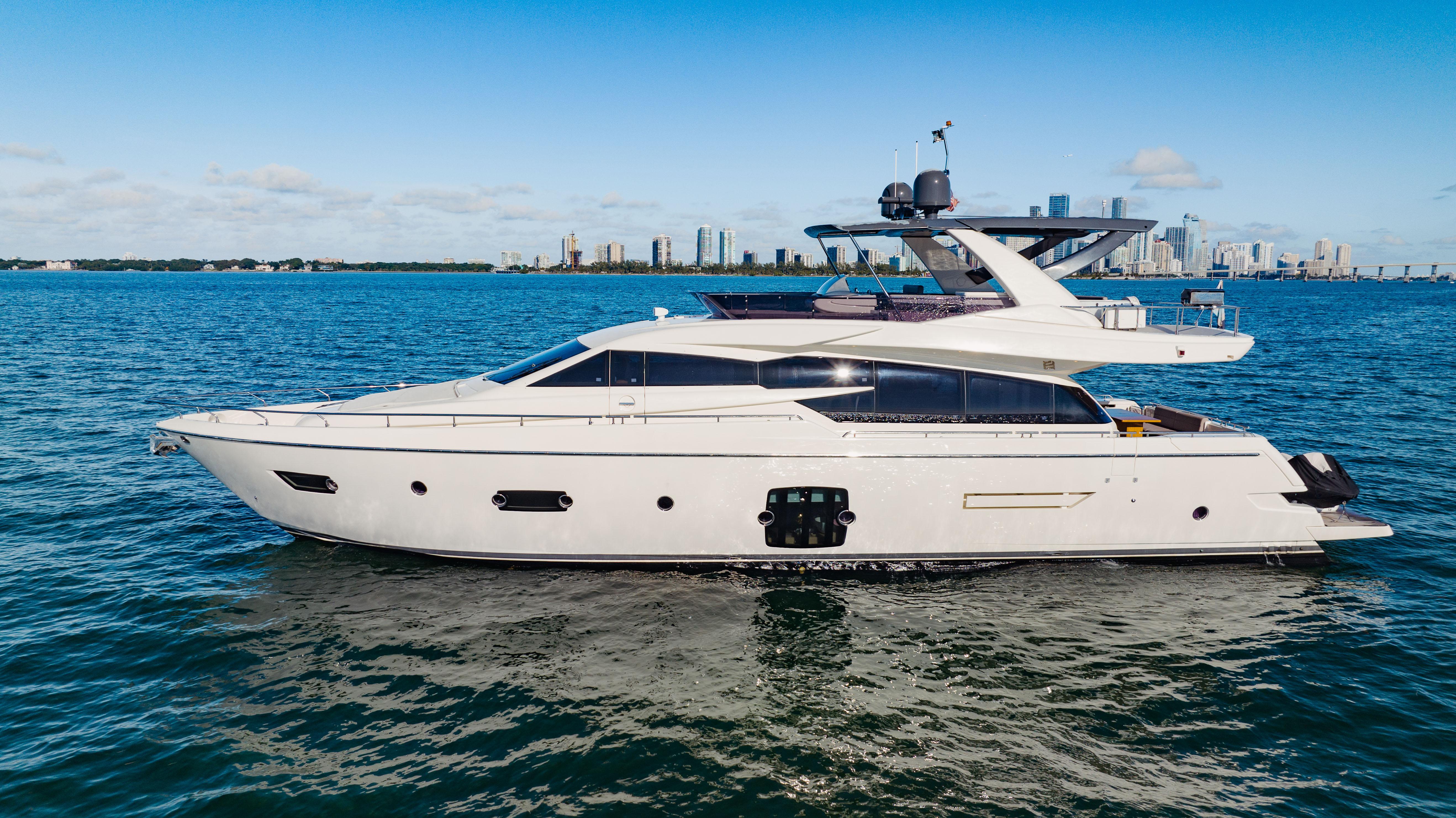 2017 Ferretti Yachts 750 cruising on blue waters with city skyline in background.