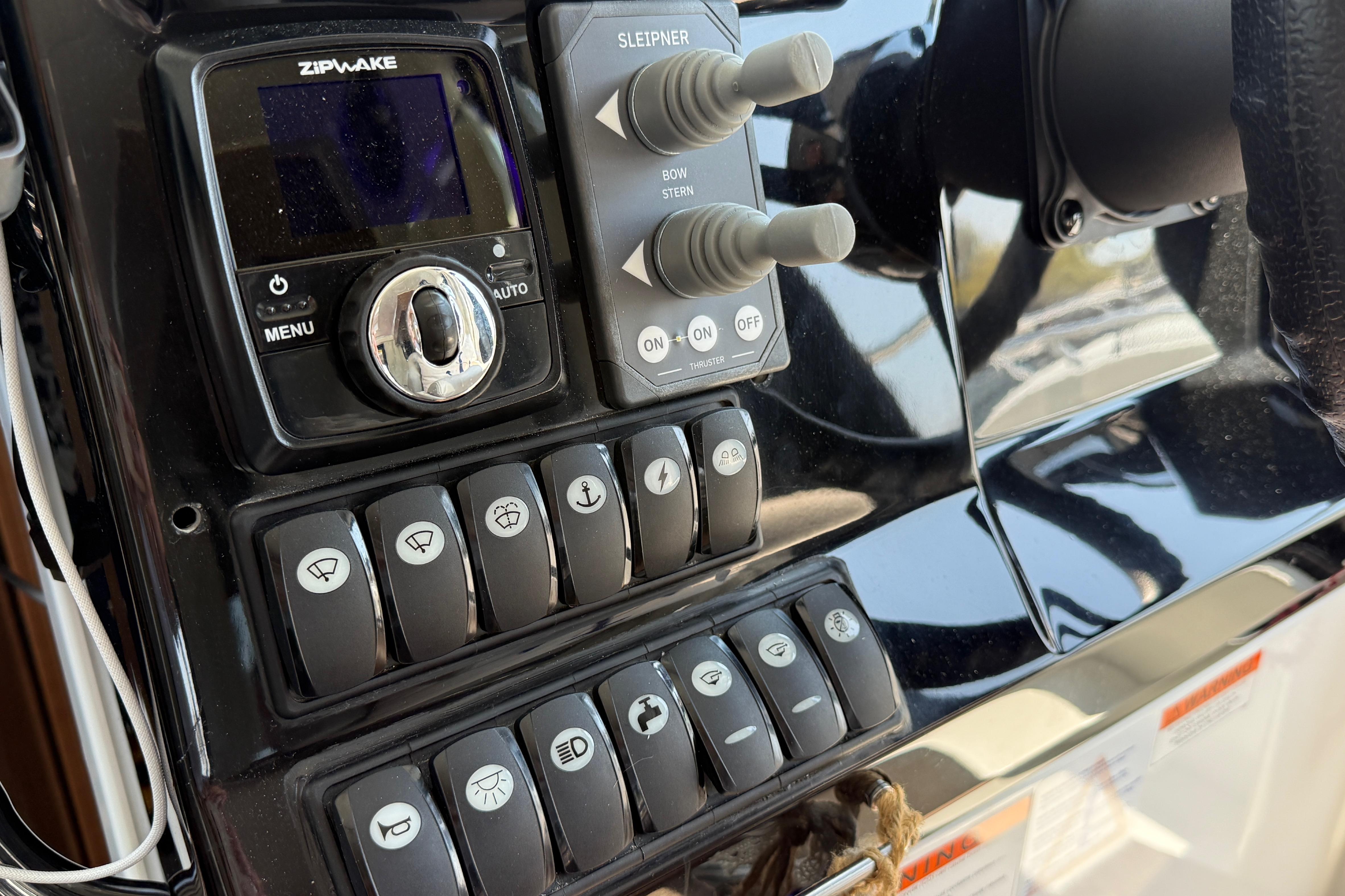 Control panel of 2022 Jeanneau NC 1095 Fly boat with various switches and controls.