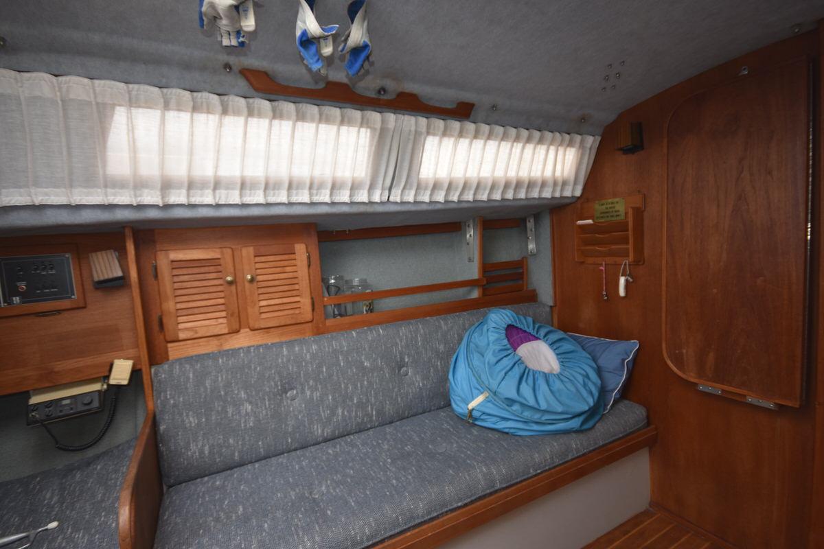 Interior of a 1987 S2 9.2A with gray sofa and wooden furnishings.
