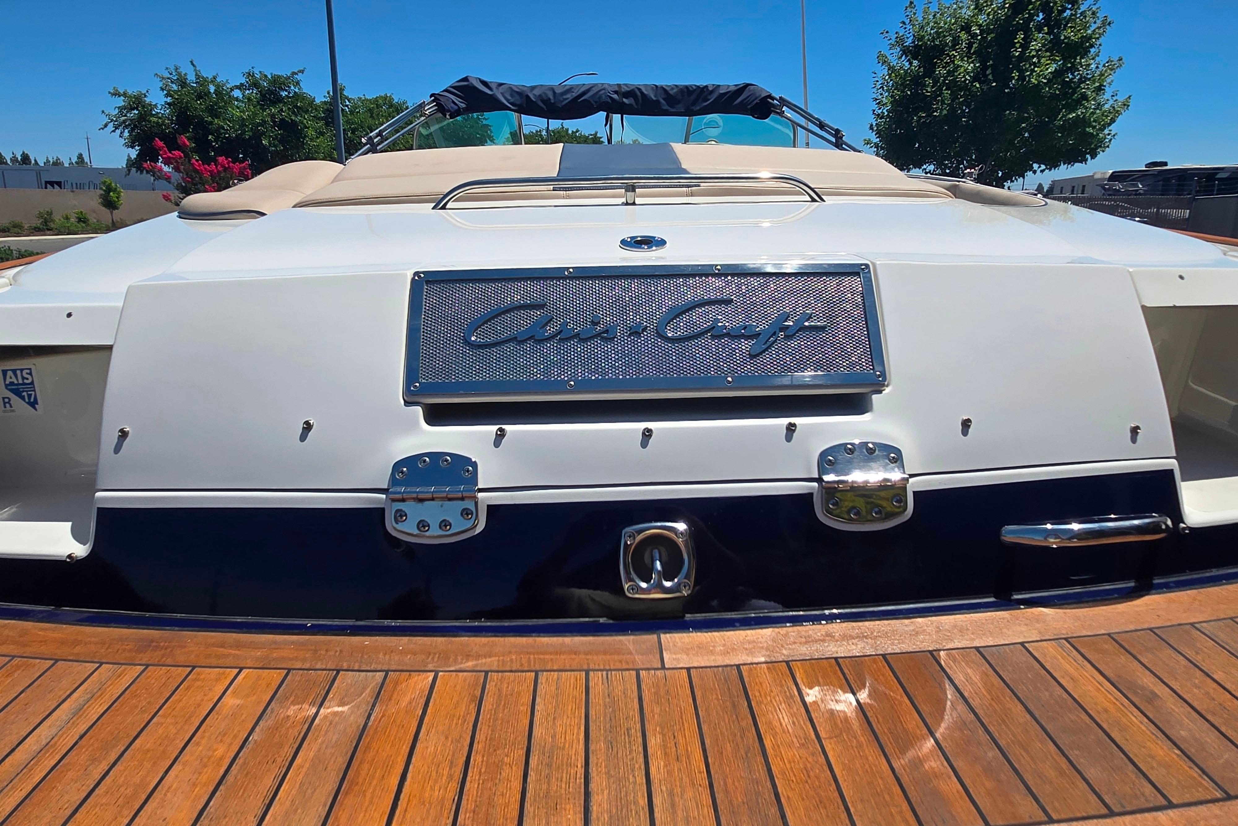 Chris-Craft Launch 28 GT I/O 2002 boat, rear view on wooden deck.