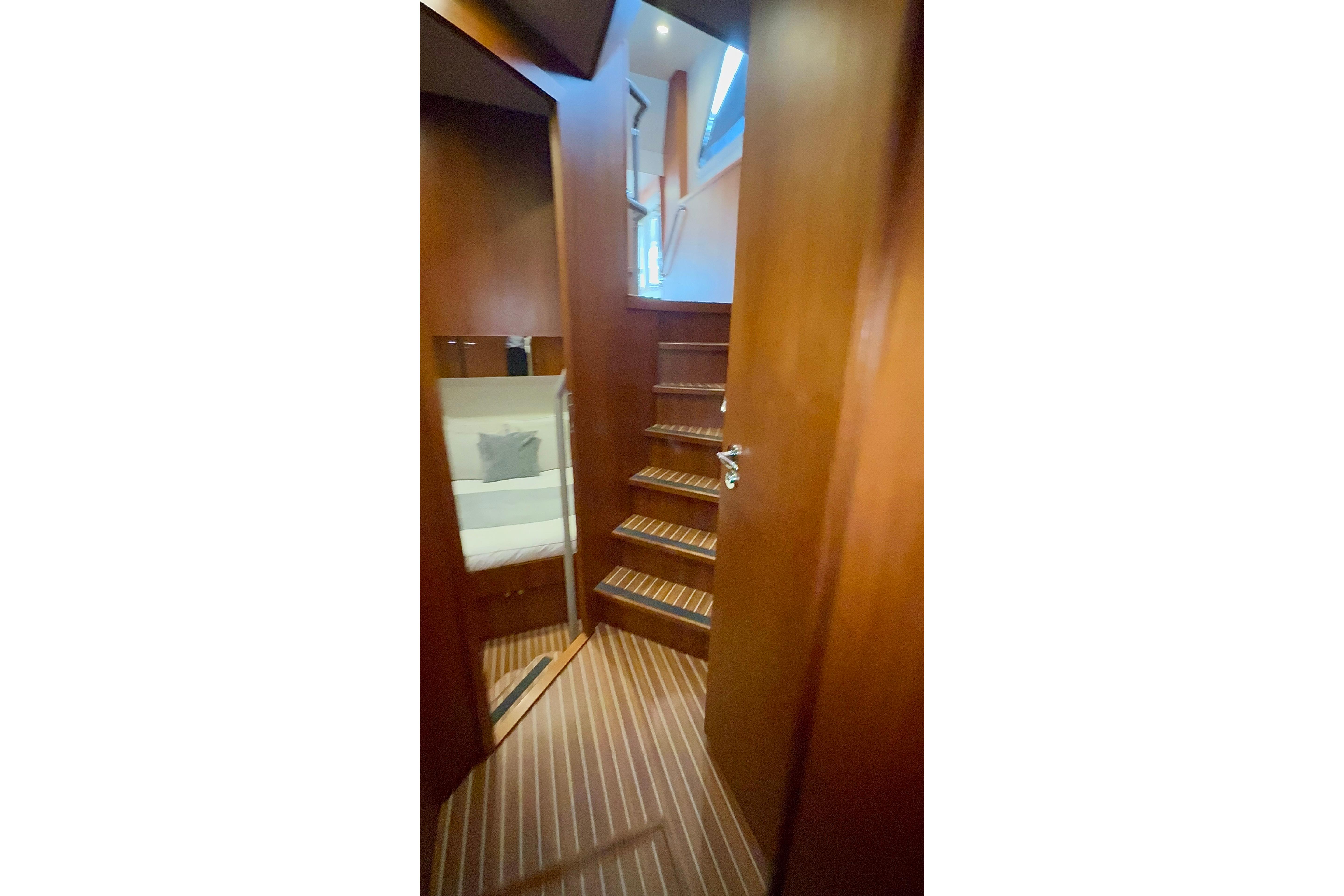 Interior view of 2015 Privateer Trawler 54, featuring wooden stairs and cozy seating area.
