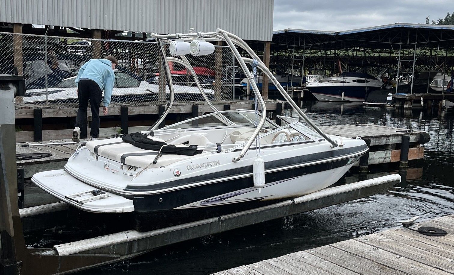 A 2011 Glastron GT 185 is docked. A person is working on the boat.
