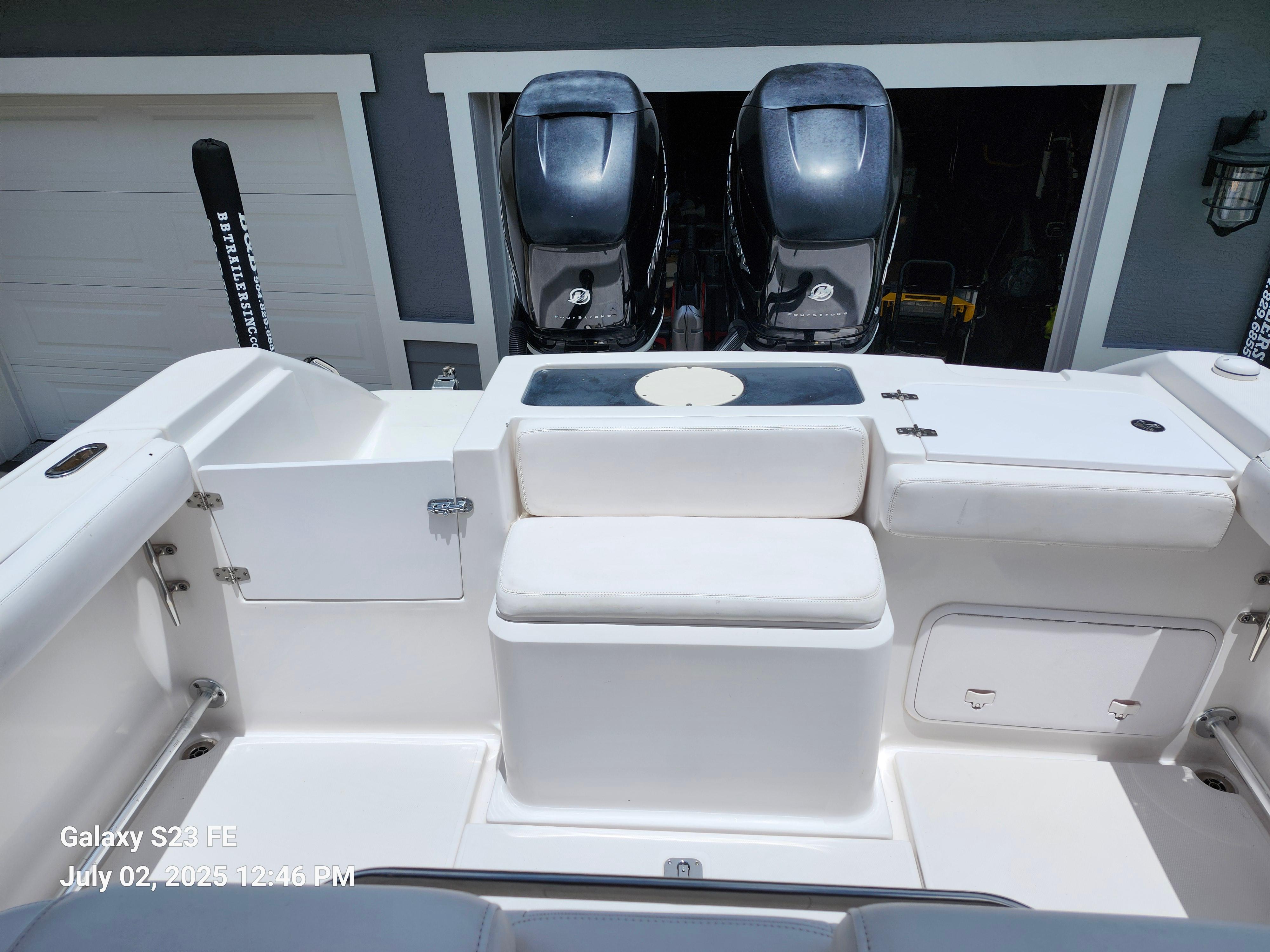 2010 Donzi 29ZF boat interior with dual Mercury engines, white seating, and storage compartments.