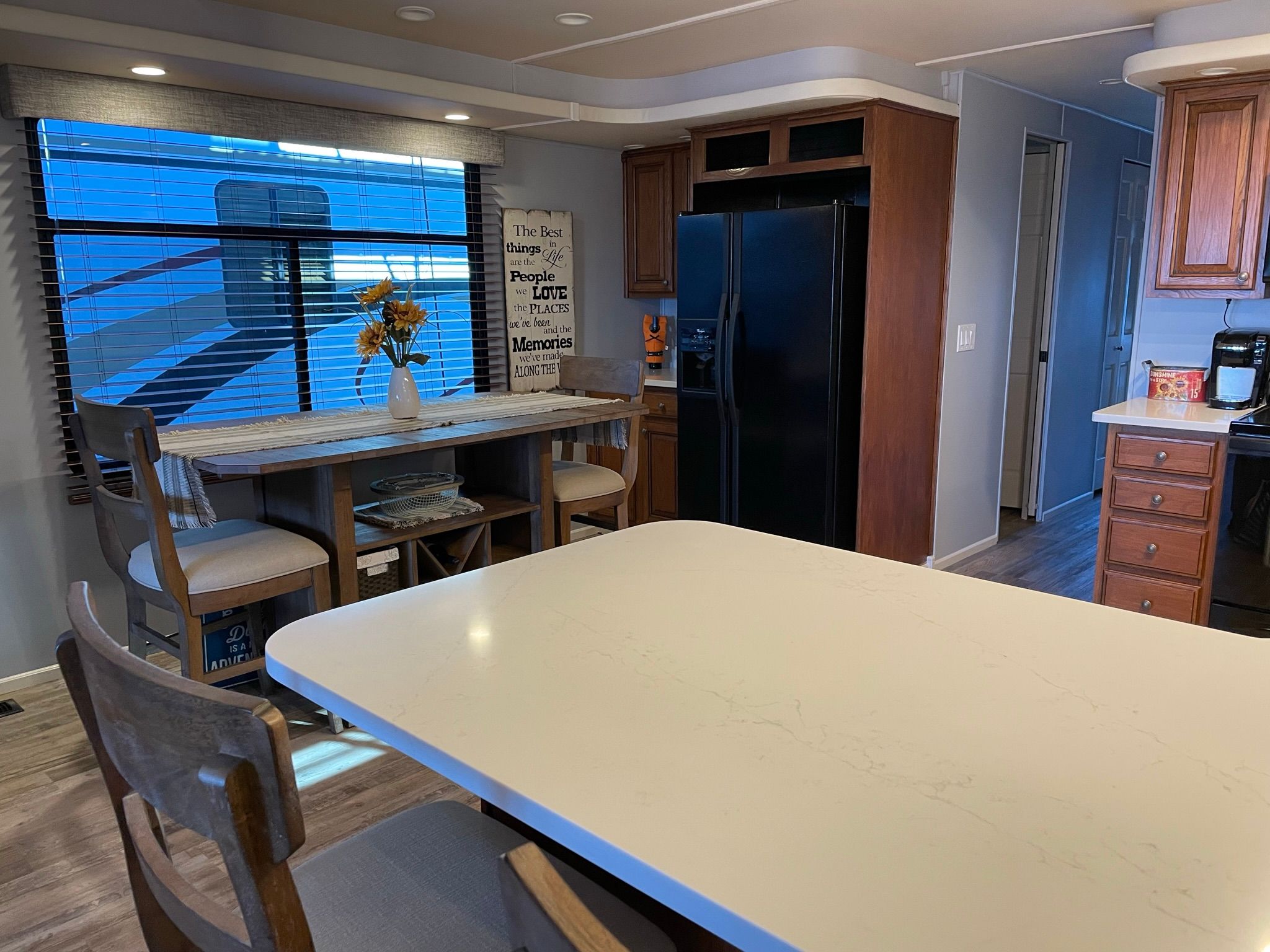 Interior of a 2001 Sumerset houseboat kitchen with dining table and refrigerator.