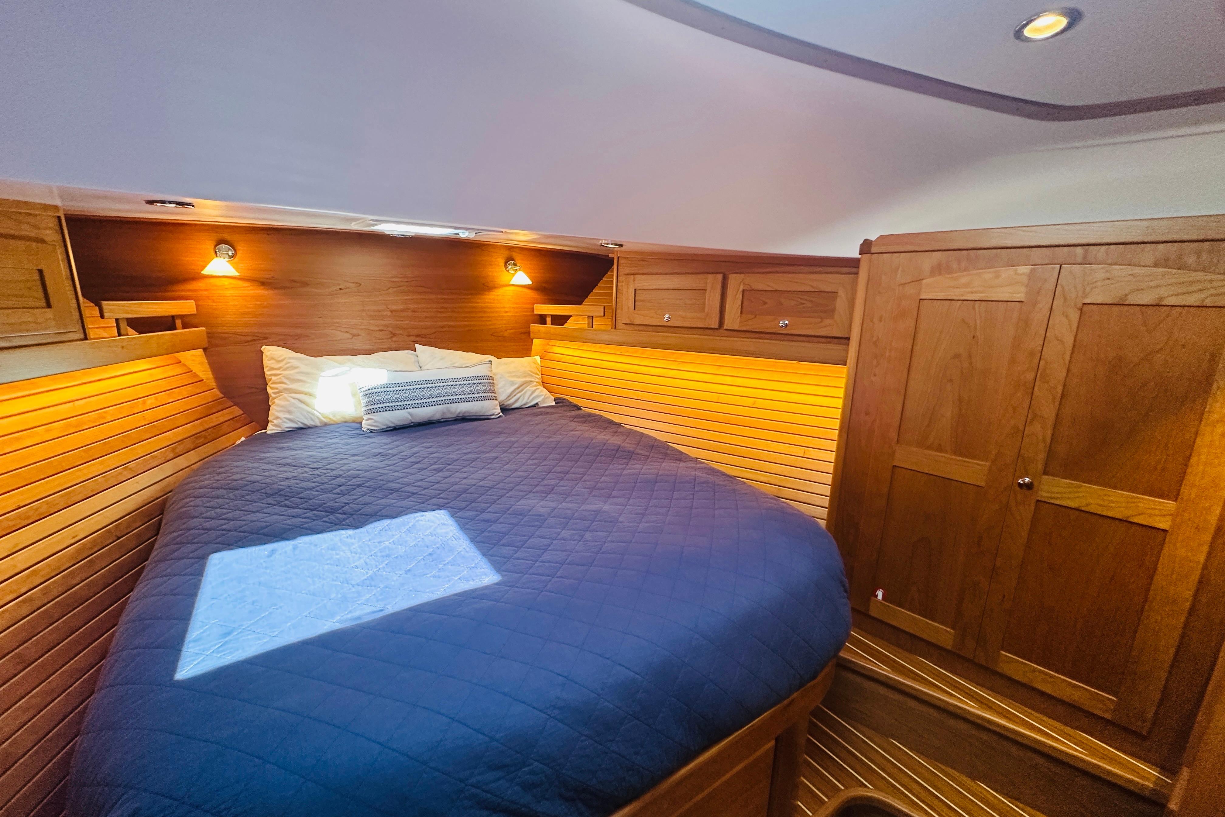 Cozy cabin interior of 2025 Sabre 48 Salon Express with wooden finishes and ambient lighting.