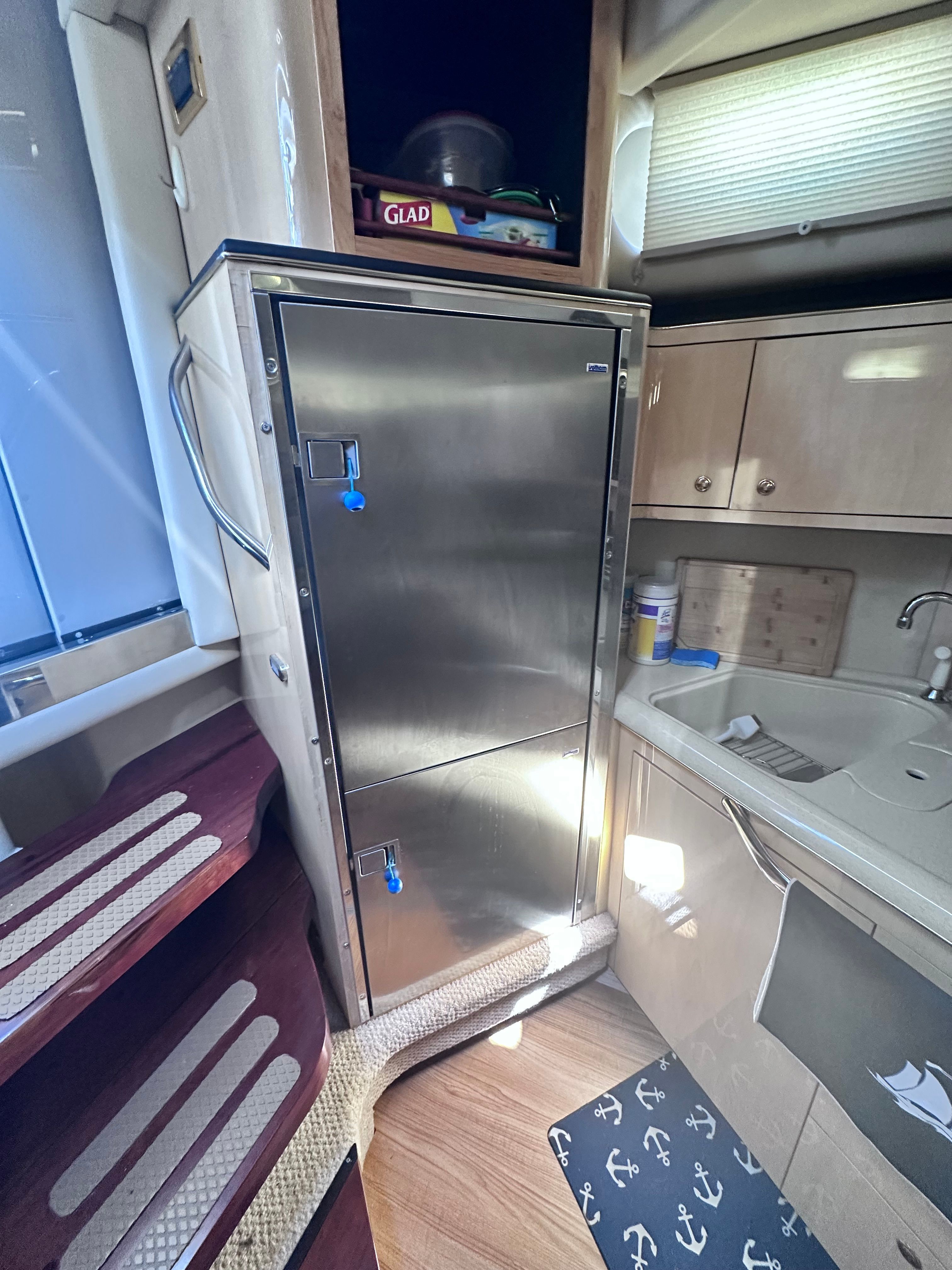 Interior of 2000 Sea Ray 380 Sundancer with stainless steel fridge and compact kitchen area.