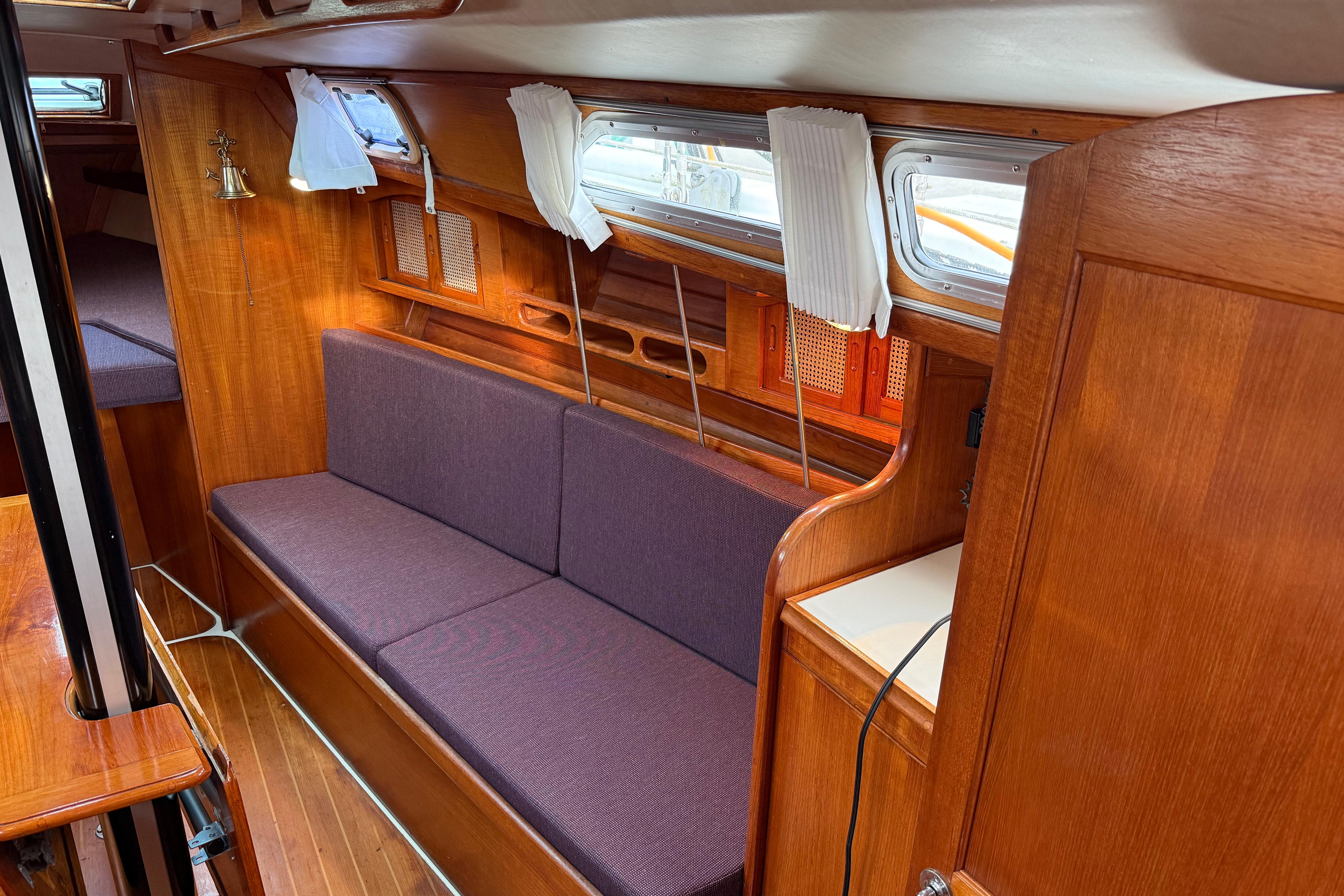 Interior of 1988 Ericson 32-200 sailboat with wooden finish and purple seating.