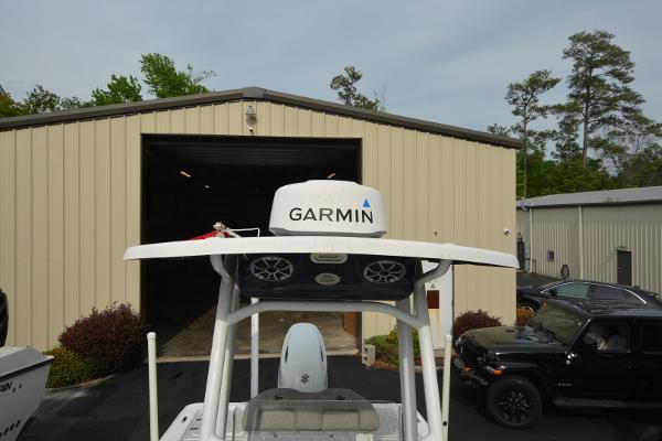 2021 Sea Pro 228 Bay boat with Garmin radar, parked near a beige warehouse.