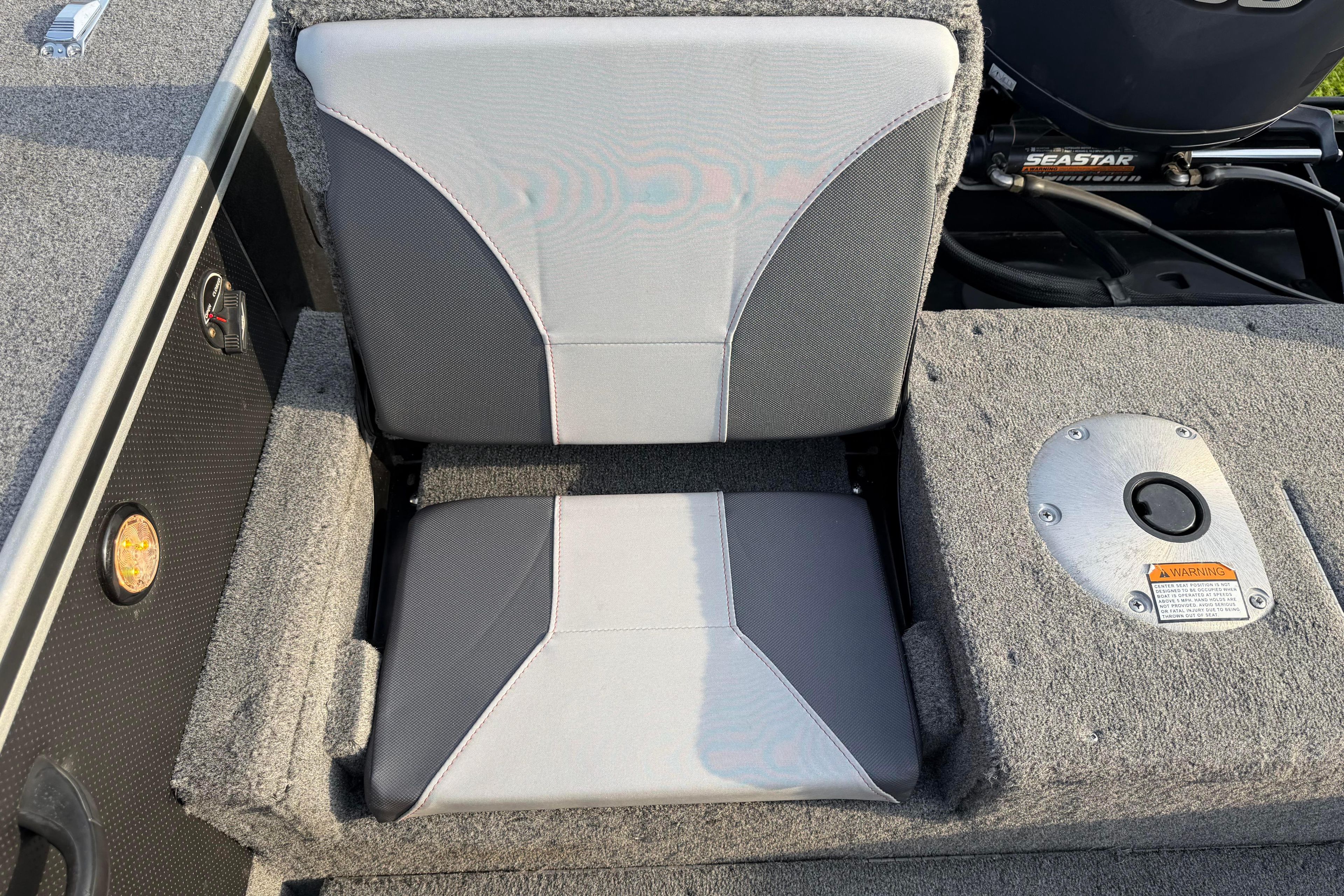 2019 Alumacraft Trophy 205 boat seat with gray upholstery and carpeted flooring.
