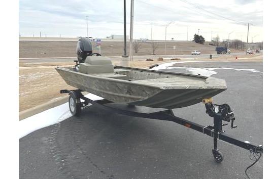 2025 Tracker Grizzly 1648 SC boat on trailer, parked outdoors under cloudy sky.